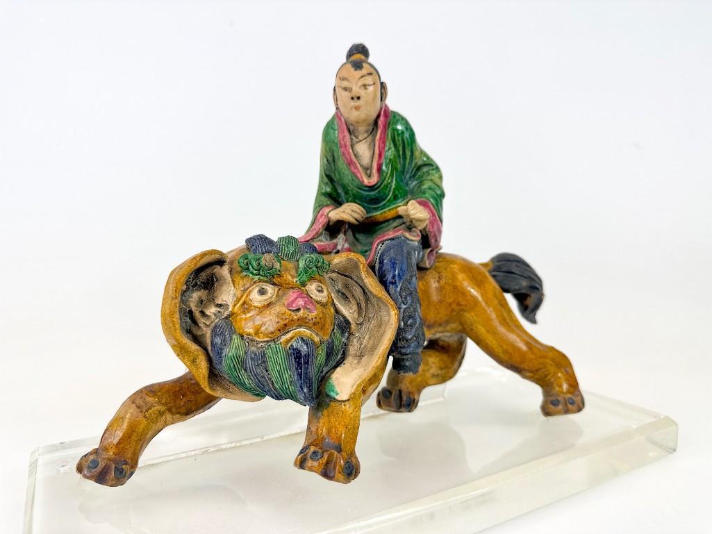 Chinese Roof Tile Man on Temple Lion: Man on Temple Lion. Mounted to acrylic base. Repair to temple lion tail and front right leg. Approx. 10.25 in. H x 14 in. x 6 in. D. Weight 7.3 lbs.