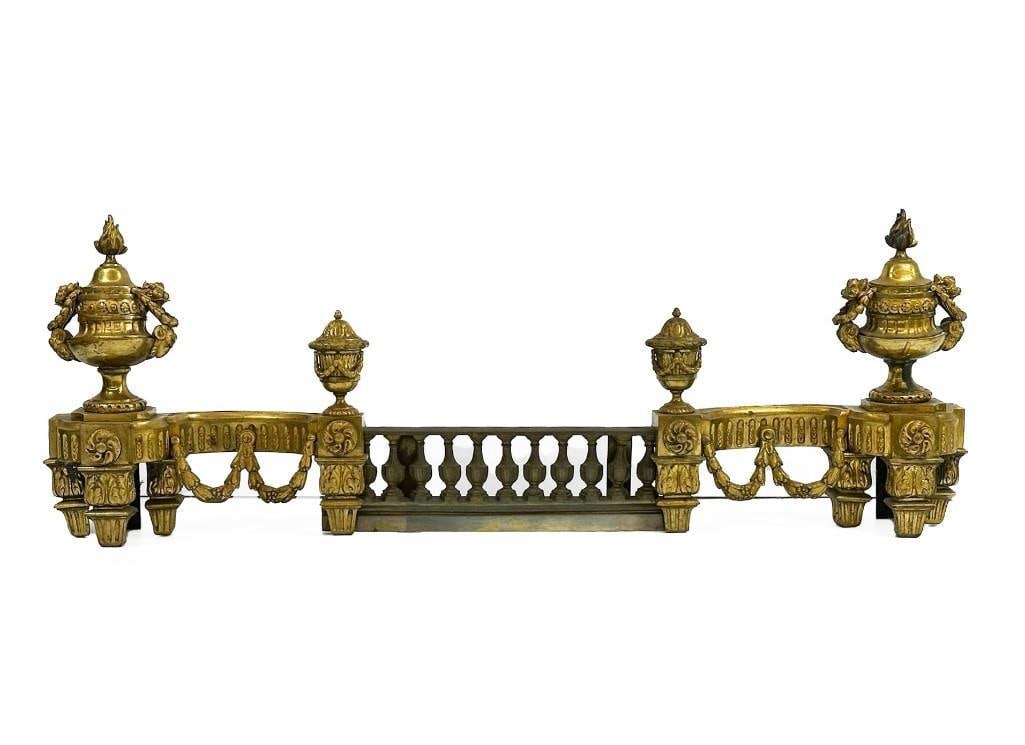 Louis XVI Style Andirions: Louis XVI Style Andirions. Some slight metal bends and patina throughout. Some discoloration on right side. See photos. Approx: side pieces: 17.75 in H x 16.75 in W x 6.5 in D; center piece: 5.75 in H