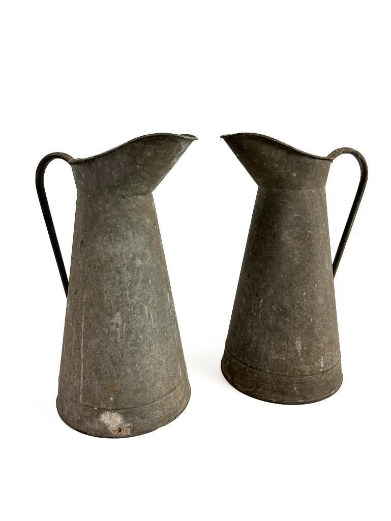 Two Antique French Zinc Pitchers: Two Antique French Zinc Pitchers One pitcher has a soft 2 inch indent, and signs of a previously repaired handle. Each pitcher measures approximately 18 in H x 11.5 in W x 9.5 in D. Total weight is ap