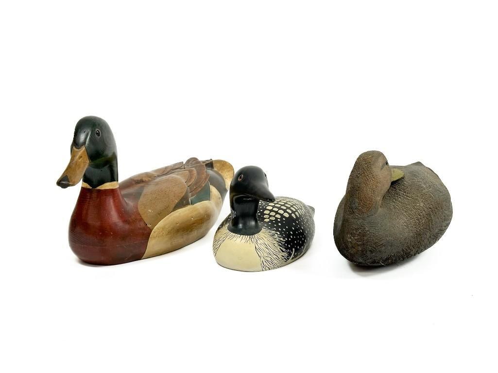 Lot of 3 Wooden Duck Decoys Tom Taber & Others: Carved wooden decoys of different duck species. One is signed Tom Taber on bottom and another has a "The Decoy Shop" stamp. Condition: Very minimal scuffs/ scratches throughout. Dimensions: Approx 8