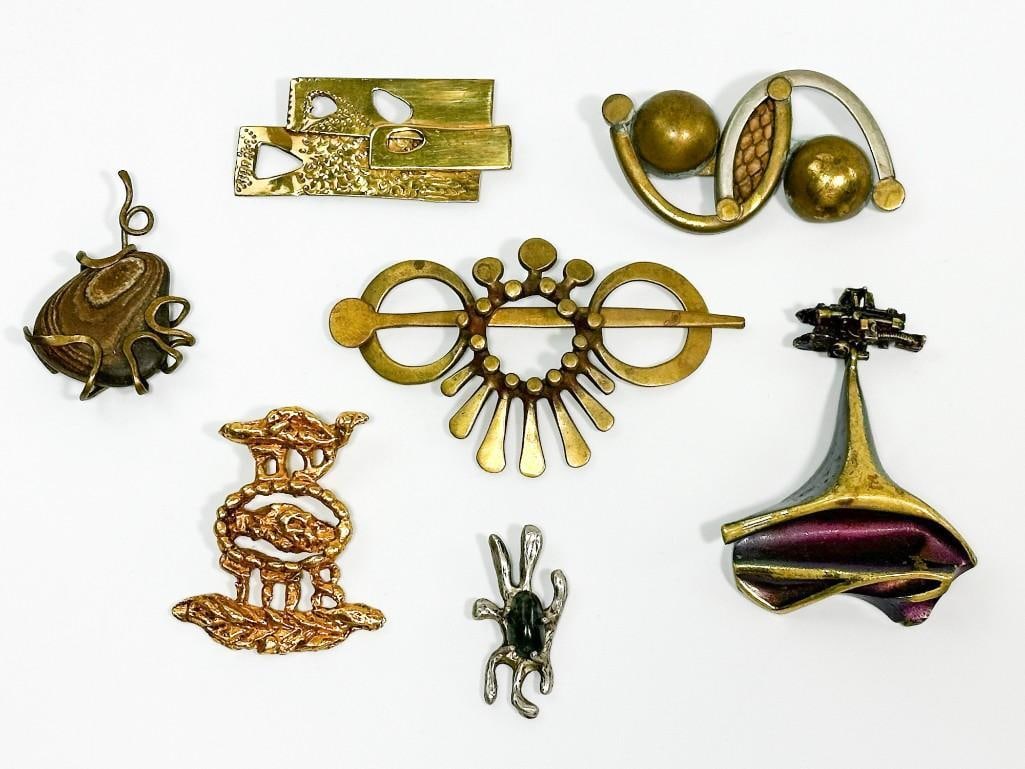 Lot of 7 Midcentury Brutalist Sculptural Jewelry Items: Seven pieces total. Makers include Wilma Spagli, Lapponia Bjorn, Jacques Lipchitz and others. Condition: Very good condition overall. Dimensions: Sizes range from approx. 1.75 in. to 4 in. <