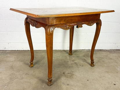 French Style Inlaid and Carved Wood Table: Carvings along legs. Appears to be table top combined with a different base. Inlaid wood on table top.  Condition: Very good. Some surface wear.  Dimensions: Table is approx. 31.5 in H x 44 in W x 27