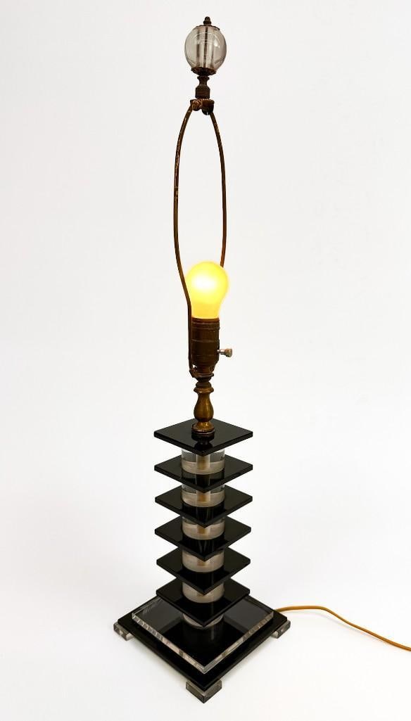 Vintage Art Deco Lucite Table Lamp: Lamp features alternating pieces of dark green slabs with clear cylinders of lucite. Condition: Some surface wear. Tested and working. Dimensions: Approximately 27 in H x 6.25 in W x 6.25 in D. Total 