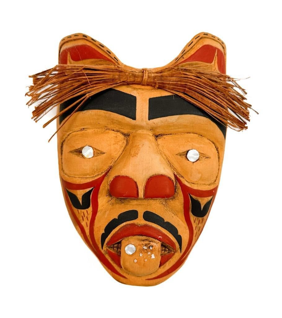 Bonnie Mack, Carved Cedar Northwest Coast Indian Mask with Pigment and Abalone Inlay, 2000: Signed and dated on the back. Condition: Good condition. Discoloration to wood and surface wear. Some raffia is cracked. Dimensions: Approximately 6 in H x 5 in W x 1.25 in D. Weighs approximatel