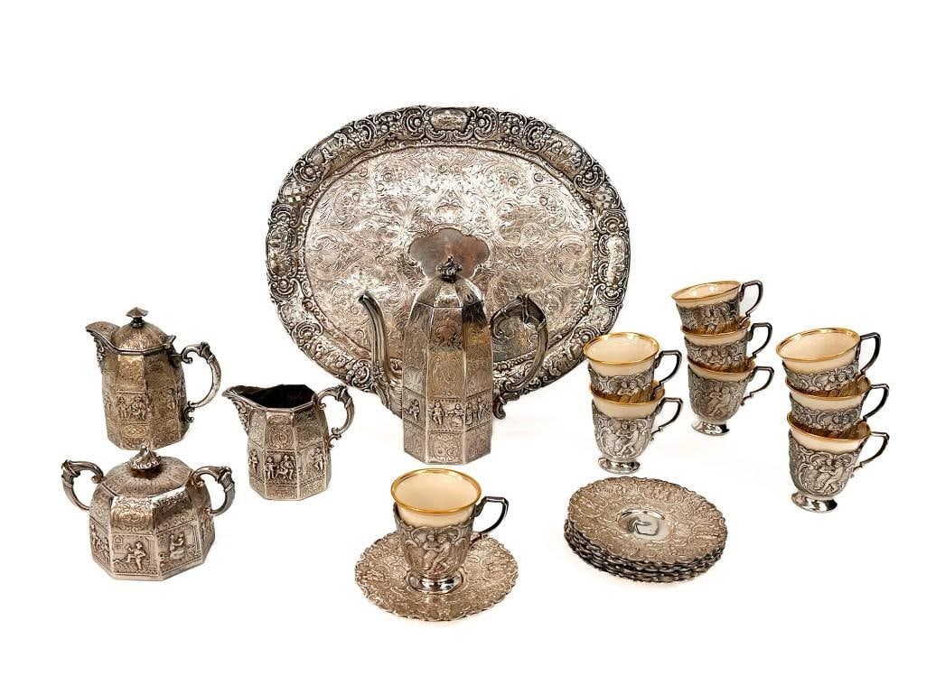23 Piece Antique E.G. Webster Repousse Silver Plate Tea Set: Tea set features 9 teacups with saucers, sugar and creamer vessels, a coffee pot, a tea pot, and a serving tray. Tea cups have a porcelain inset cup made by Lenox. Condition: Good condition. No visib