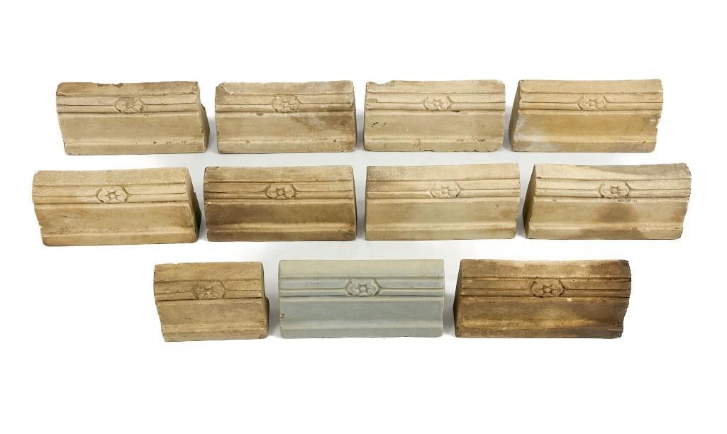 Lot of 11 Trim Tiles w/ Floral Design: Marked on back. One light blue glazed tiel. Condition: Some chips. Some surface wear. Dimensions: 3 in H 5.75 in W x 1.5 in W. Overall weight 12 lbs 15 oz.