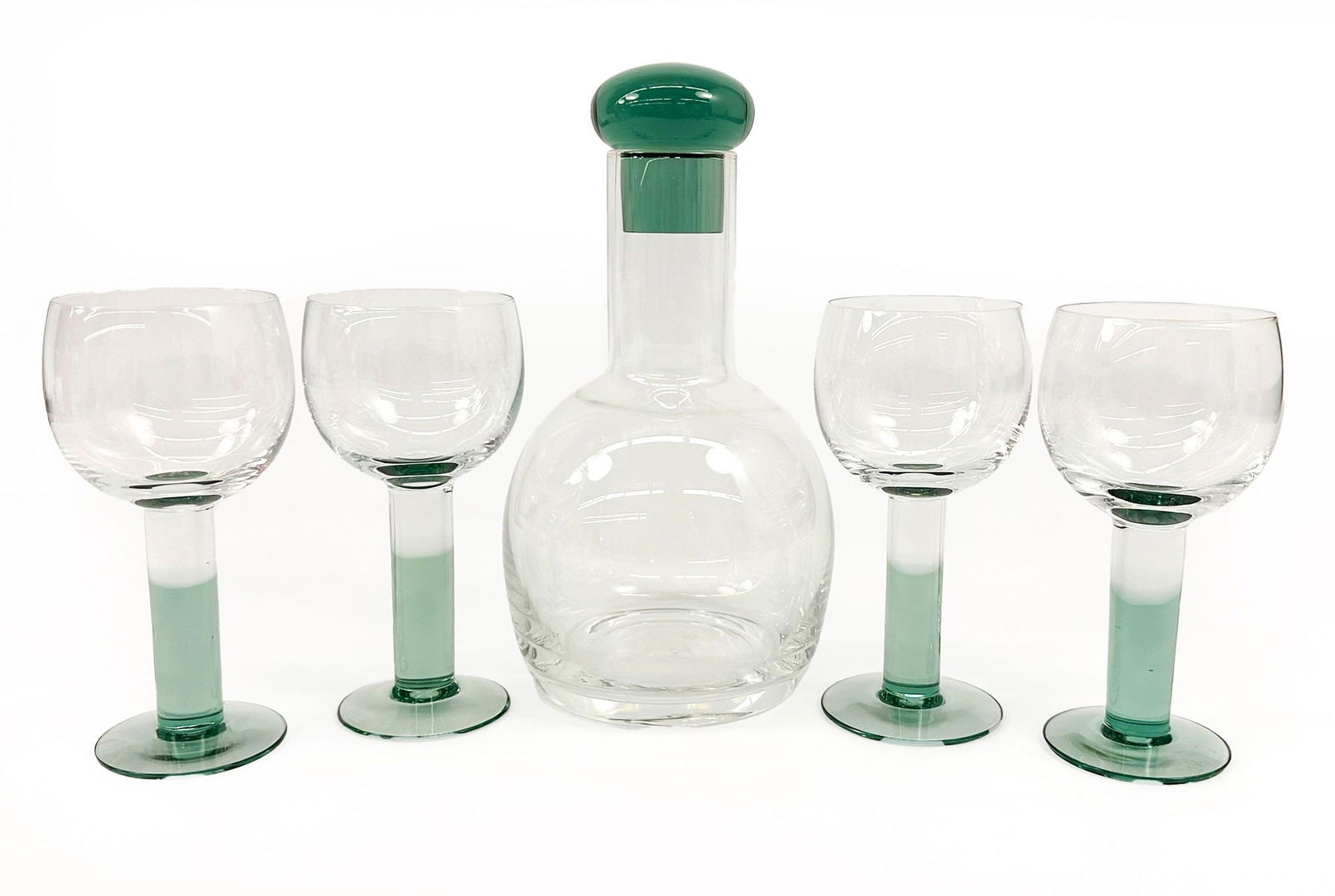 Set of Vintage Iittala Mondo Crystal Goblets and Decanter: Lot includes 4 goblets and one decanter with lid. Glassware has blue-green to clear hues. Comes in original boxes. Each glass is approximately 6.5 in H x 3 in W x 3 D. Decanter is approximately 10 in
