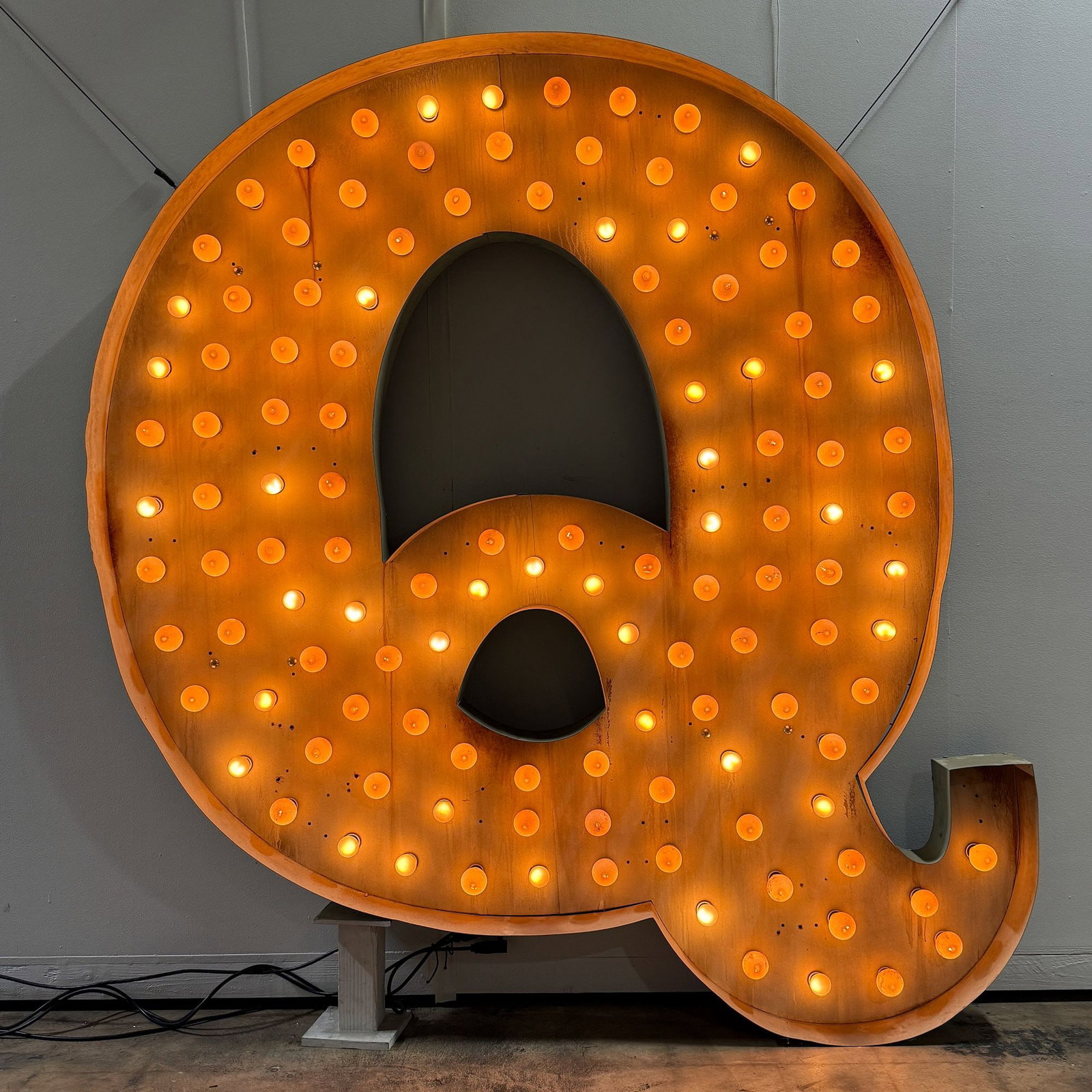 Large "Q" Vintage Inspired Channel Letter Animated Lighted Sign: Eye-catching bulb channel letter "Q" features a vintage marquee style, with dozens of exposed bulbs for a bold, warm glow. Film/Television Appearance: Miracle Workers & other vario
