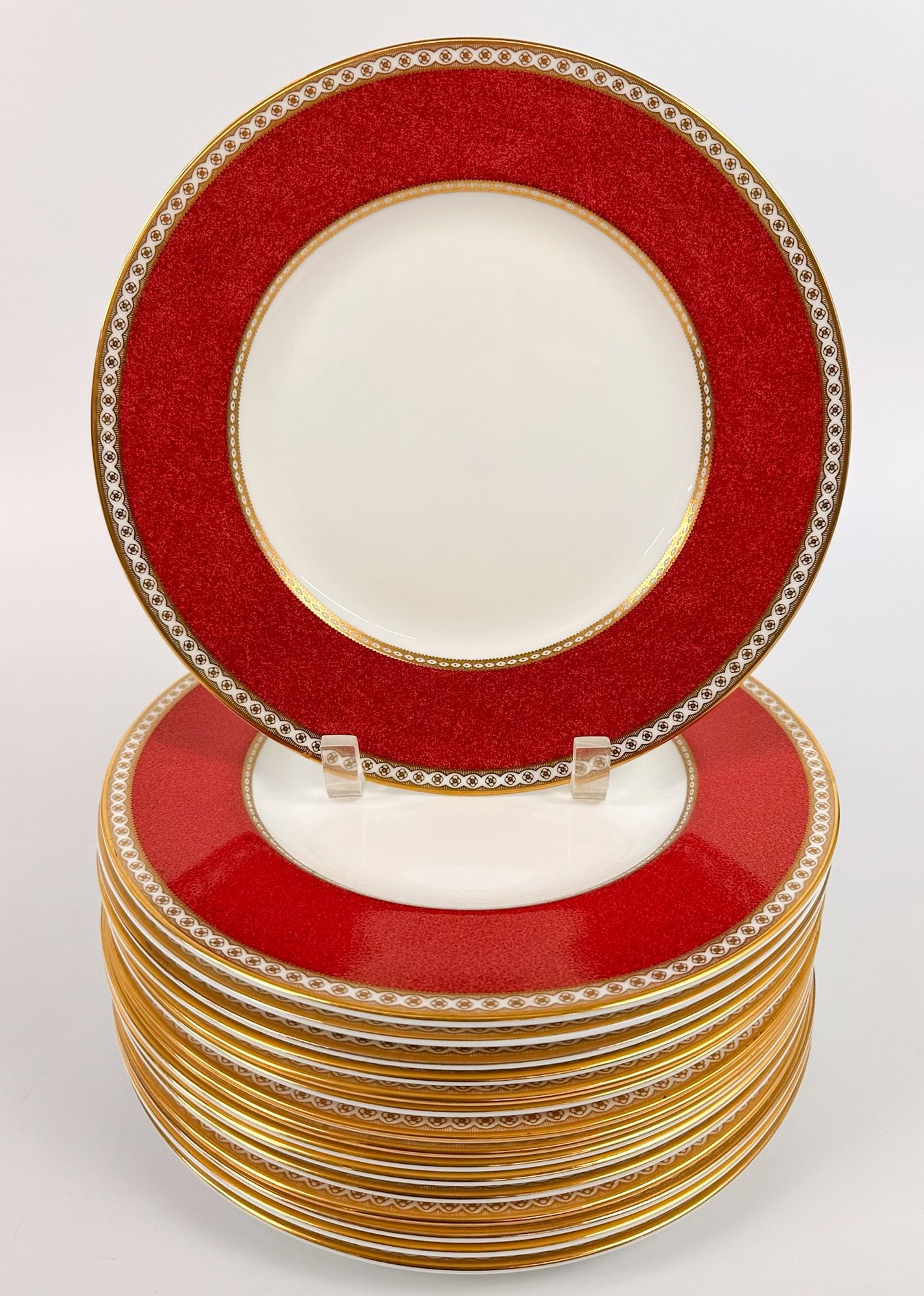 Set of 16 Wedgewood Ulander Powder Ruby Bone China Dinner Plates: Set comes in a ulander red and cream color way with neoclassical gilt gold detailing. Stamped on the back side. Each plate is approximately 10.75 inches in diameter. Total weight is approximately 22 l