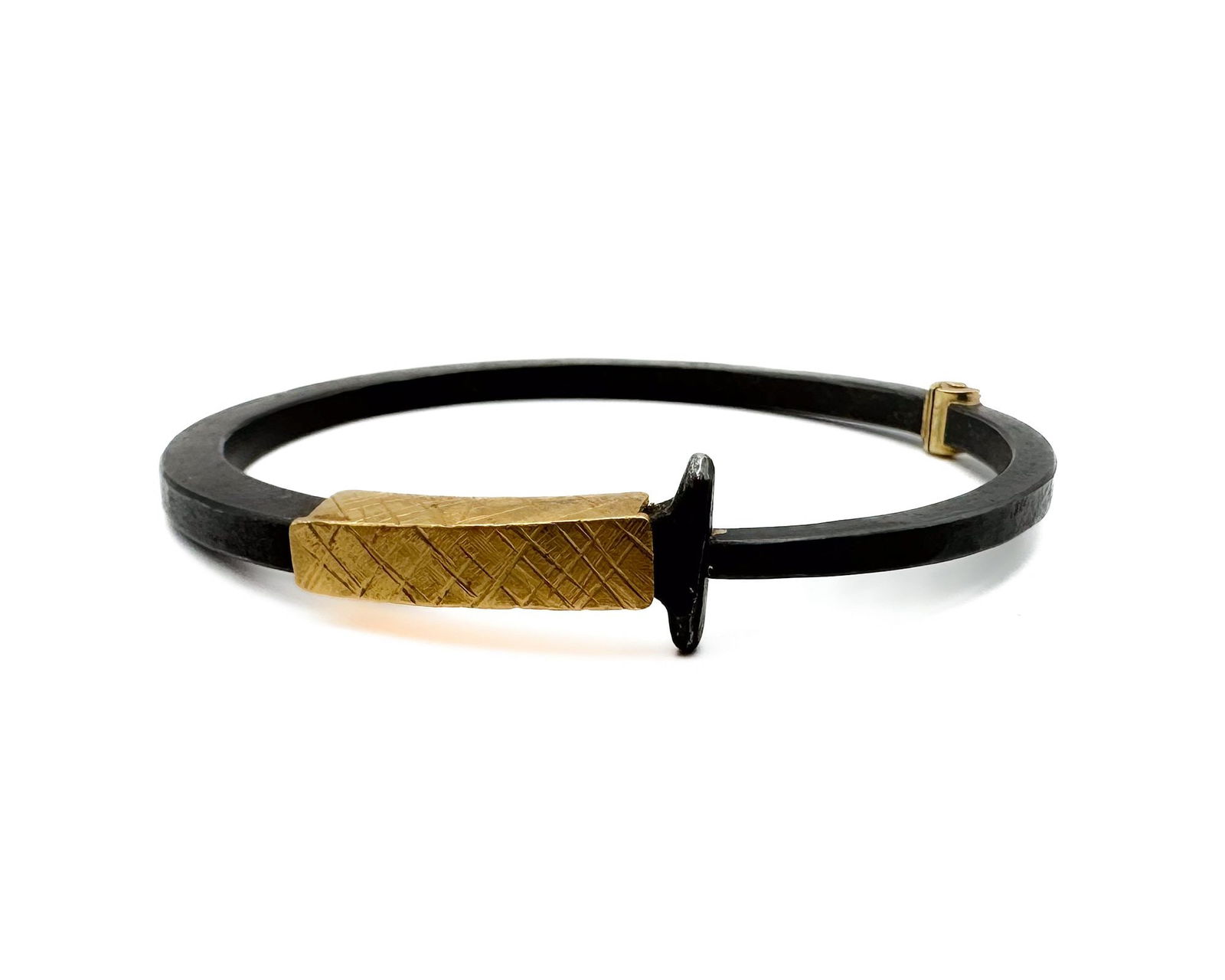 Pat Flynn Iron Nail & 22K Gold Collar Bracelet: Pat Flynn iconic nail bracelet featuring hand-forged iron nail contrasted with rich textured 22K gold collar. 18K gold hinge. Designer signed. Interior dimensions: 2.375 inches by 2 inches. Iron width