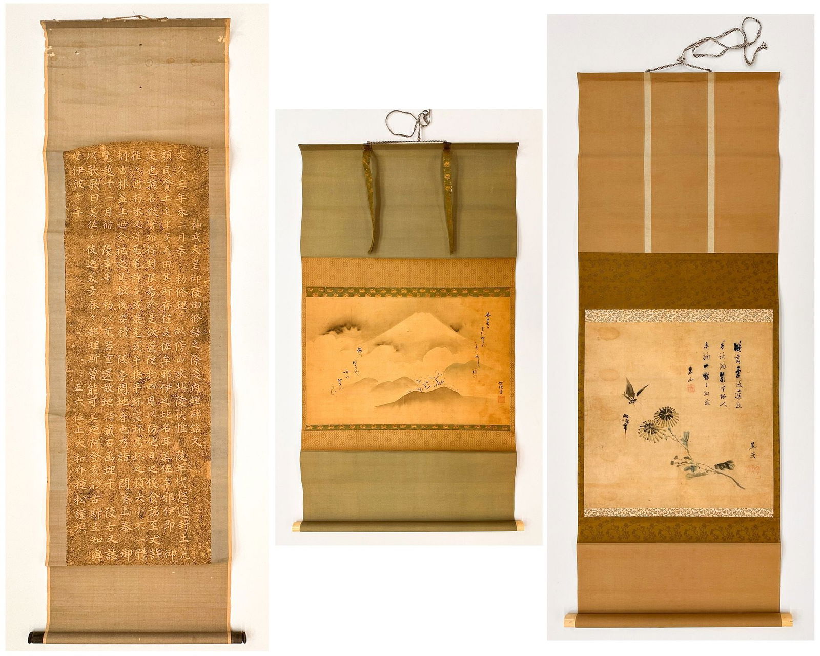Lot Of Three Asian Scrolls: Buddhist Sutra, Landscape, And Bird With Chrysanthemums: Traditional ink wash on paper mounted to silk. Scroll 1 (Left): Buddhist sutra text rendered in gold characters on a rich brown-gold ground. Scroll 2 (Center): Misty mountain landscape with Mount Fuji