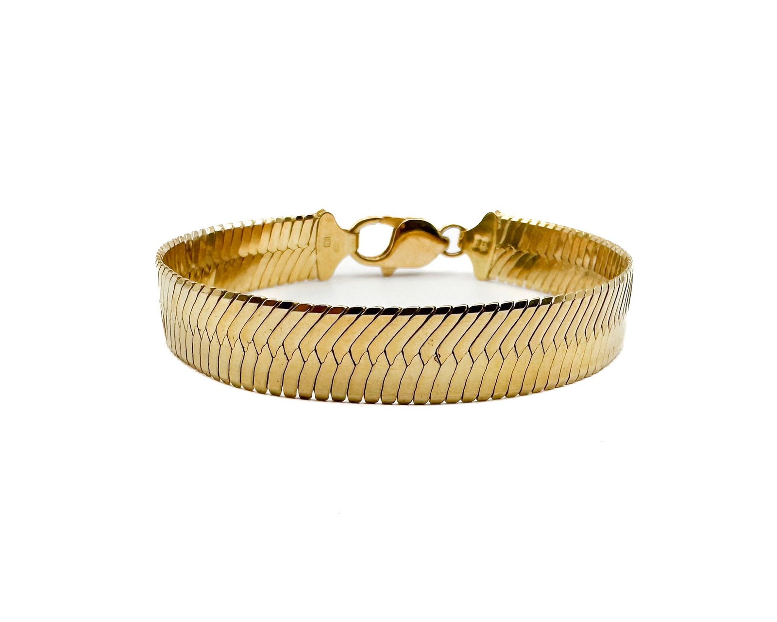 14K Yellow Gold Herringbone Bracelet, Italian Made: 14K yellow gold herringbone bracelet featuring distinctive V-shaped weave pattern. Italian craftsmanship marked Italy. Dimensions: Measures 7 inches in length and 0.5 inches wide. Total weight: 19.2 g