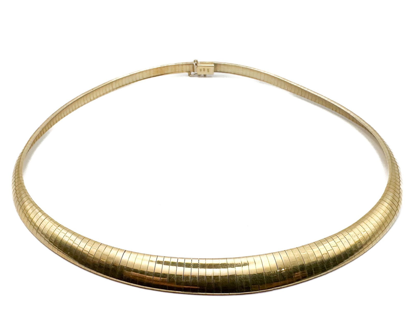14K Yellow Gold Graduated Omega Necklace, Italian Made: 14K yellow gold omega necklace featuring graduated design that widens at center. Italian craftsmanship marked Italy. Dimensions: Measures 16.25 inches in length and 0.375 inches at widest point. Impre