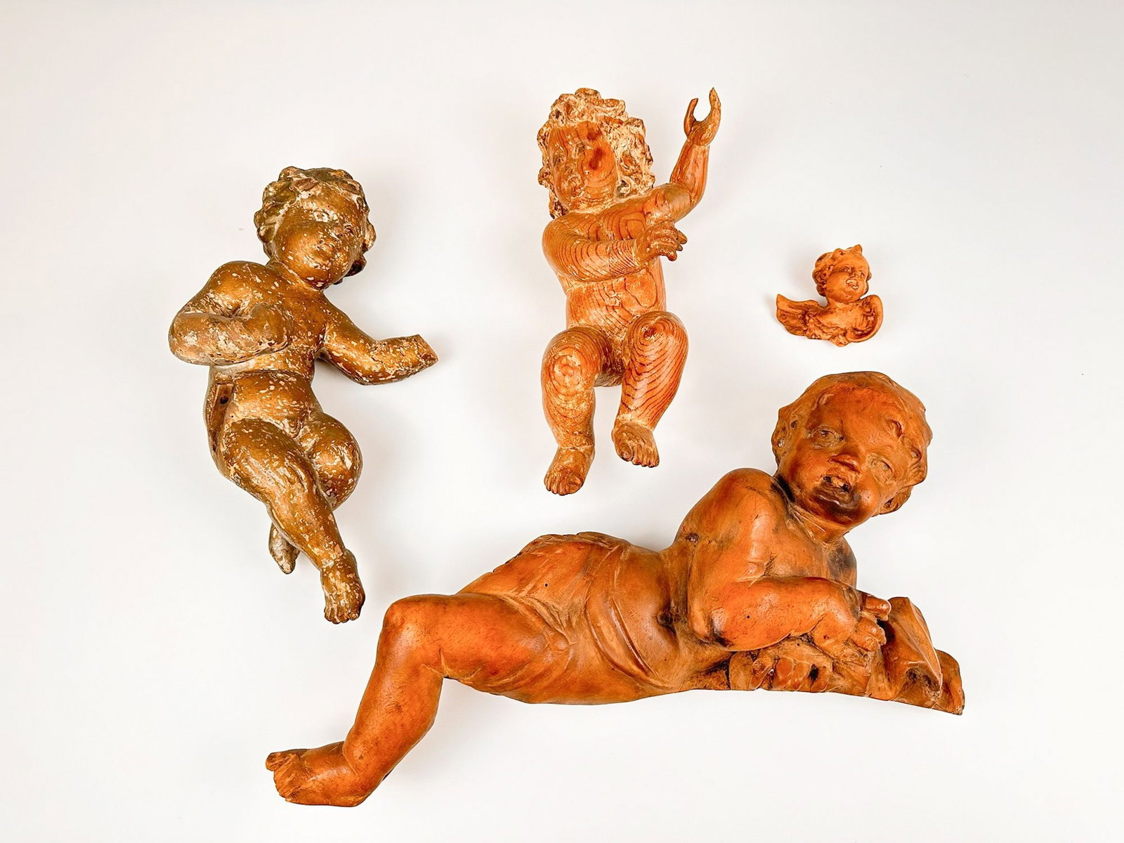 Lot of Four Vintage Carved Wooden Cherubs: Lot of Four Vintage Wooden Cherubs Lot includes cherubs of varying sizes and types of wood. Each one has a hanging apparatus installed into the back. Sizes vary from approximately 3 in H x 3 in W x 2