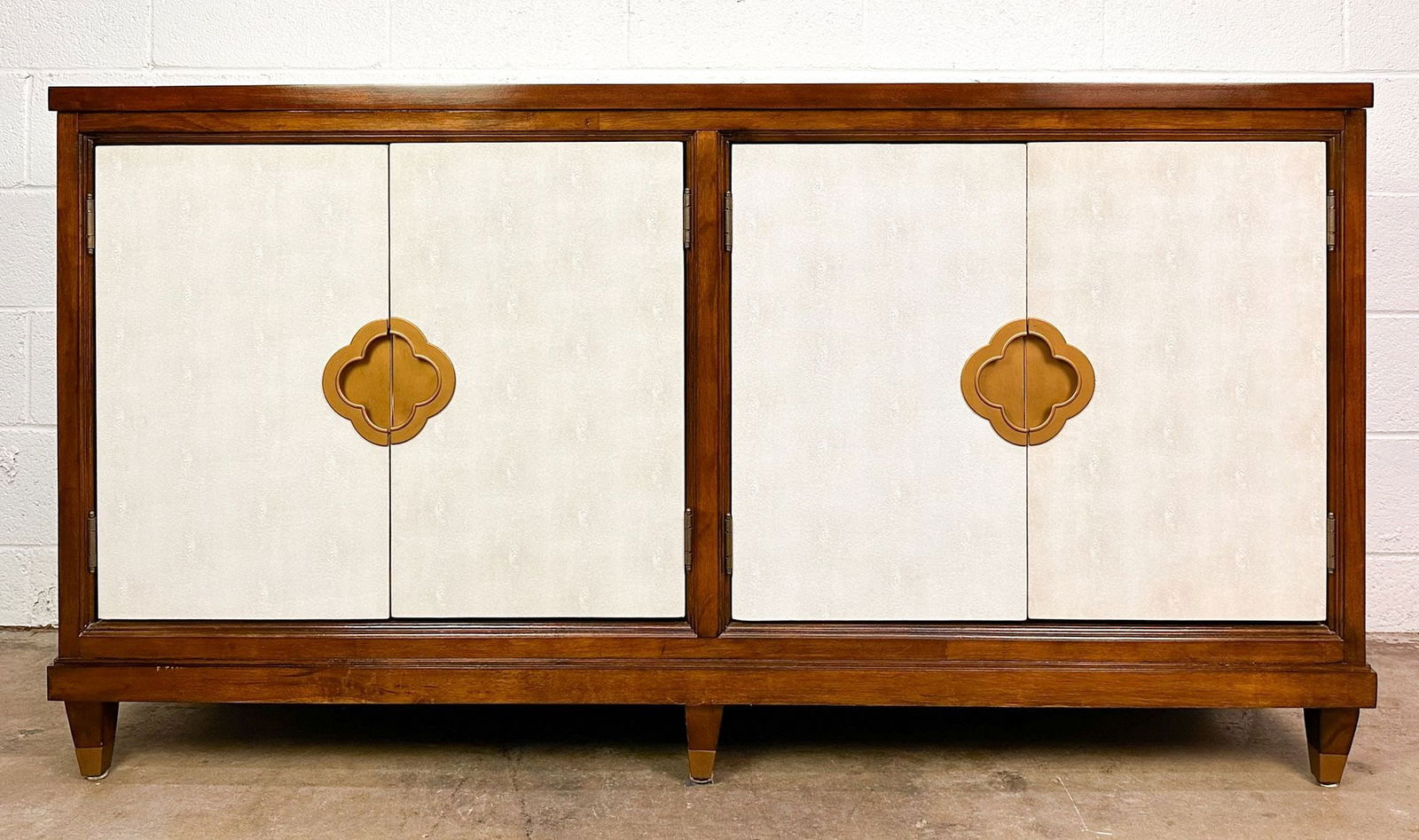 Hooker Furniture Faux Leather 4-Door Cabinet: Brushed gold pulls. Faux leather doors. Dimensions: Cabinet is approx. 34.5 in H x 64 in W x 20 in D.