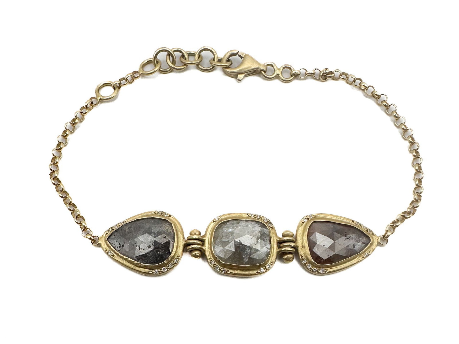18K Gold Bracelet with Rustic Diamonds: This elegant 18K gold bracelet features three rustic diamonds, accented with smaller diamonds. It measures 7 inches and can be adjusted to 6 inches. The total weight is 7.7 grams.