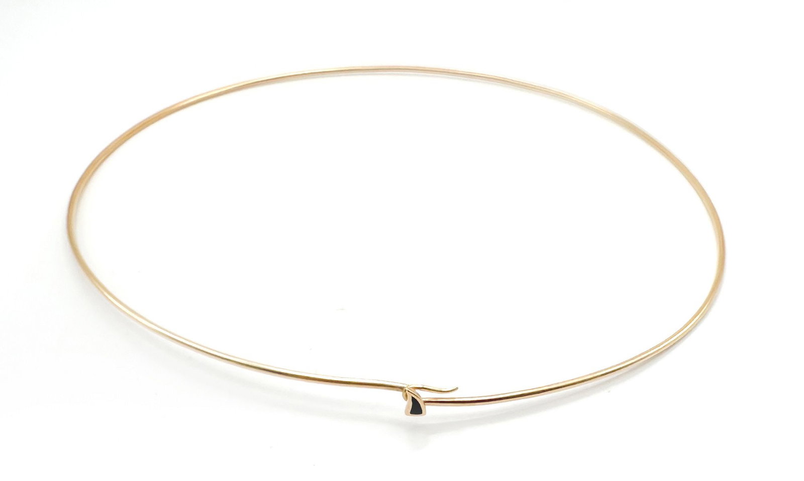 18K Yellow Gold Wire Collar Necklace with Onyx Accent: A delicate 18K yellow gold wire collar necklace featuring a small, triangular onyx accent at the clasp. The necklace measures 15 inches in length and weighs 7.4 grams. This piece offers a minimalist a