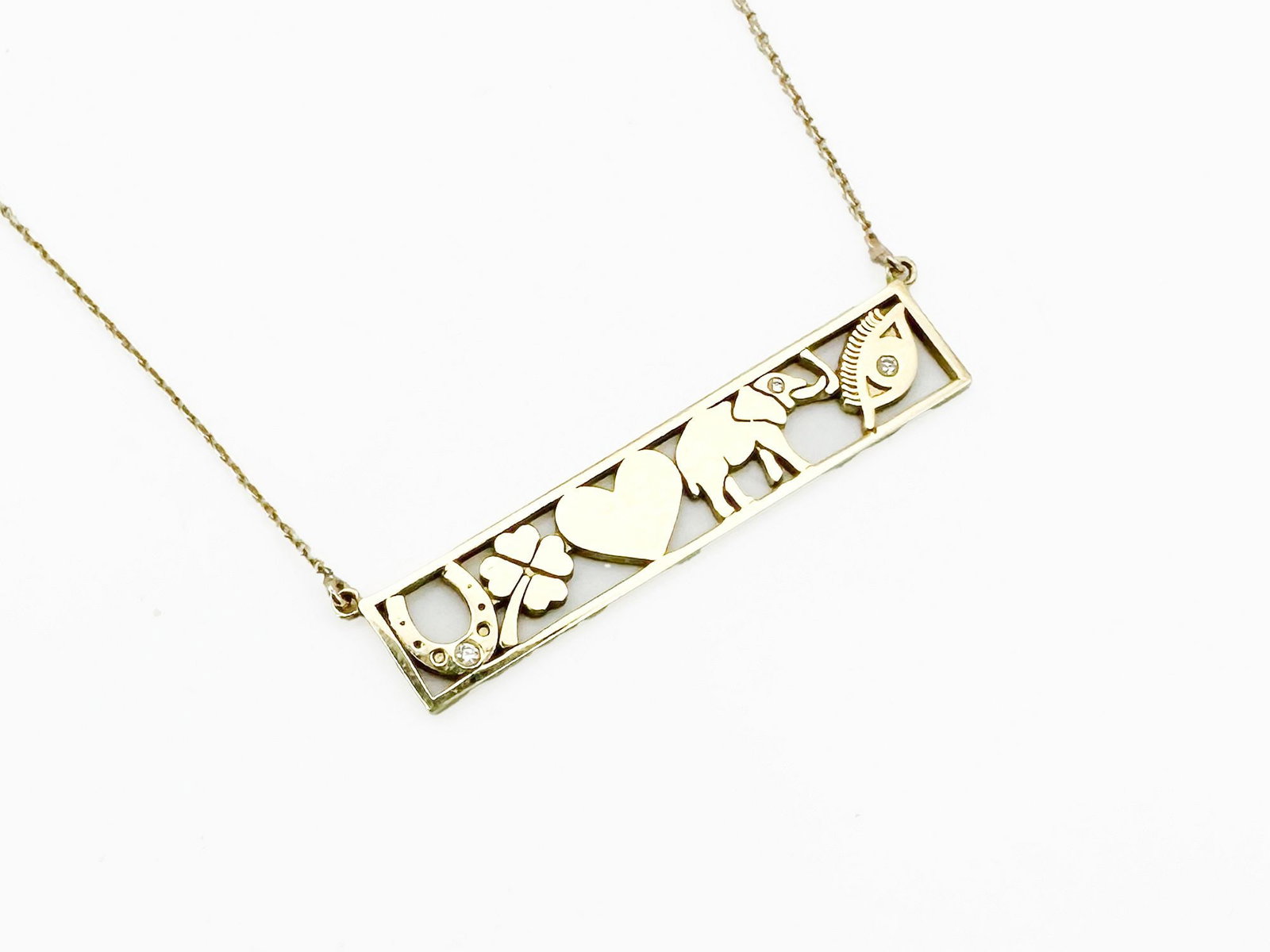Jennifer Meyer 18K Gold Diamond Good Luck Bar Necklace: Jennifer Meyer 18K gold 'Good Luck' bar necklace featuring diamond accents. The 1.5-inch bar displays a clover, heart, elephant, and horseshoe. The chain is 14K gold and measures 16 inches. To