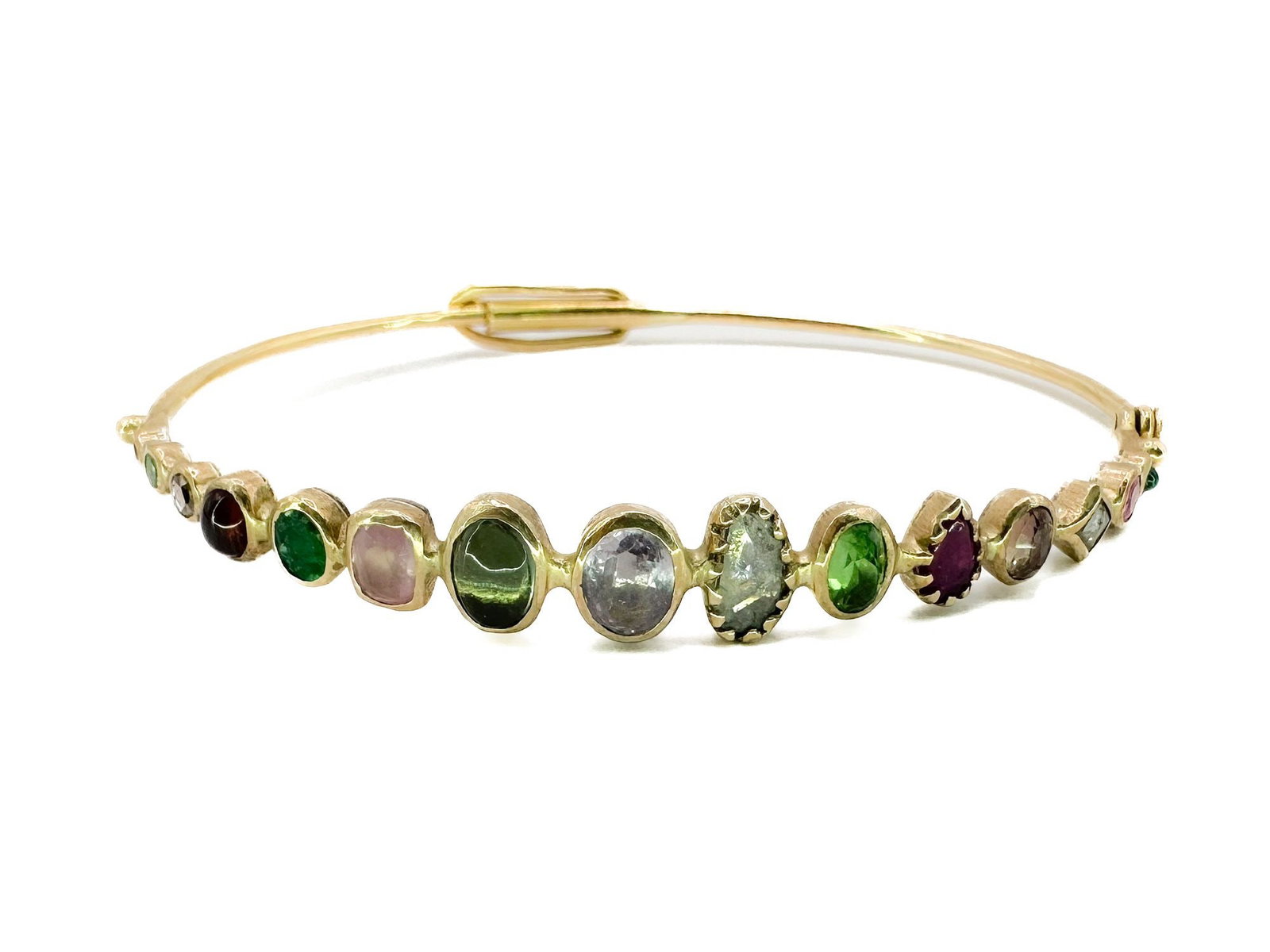 Dorette 18K Yellow Gold Multi-Gem Souriant Bangle Bracelet: Dorette bangle featuring emerald, spinel, sapphire, ruby, tsavorite, tourmaline, hessonite, and diamonds set in 18K yellow gold bezels with sterling silver backing. Interior 6 inches. Weighs 7.5 grams
