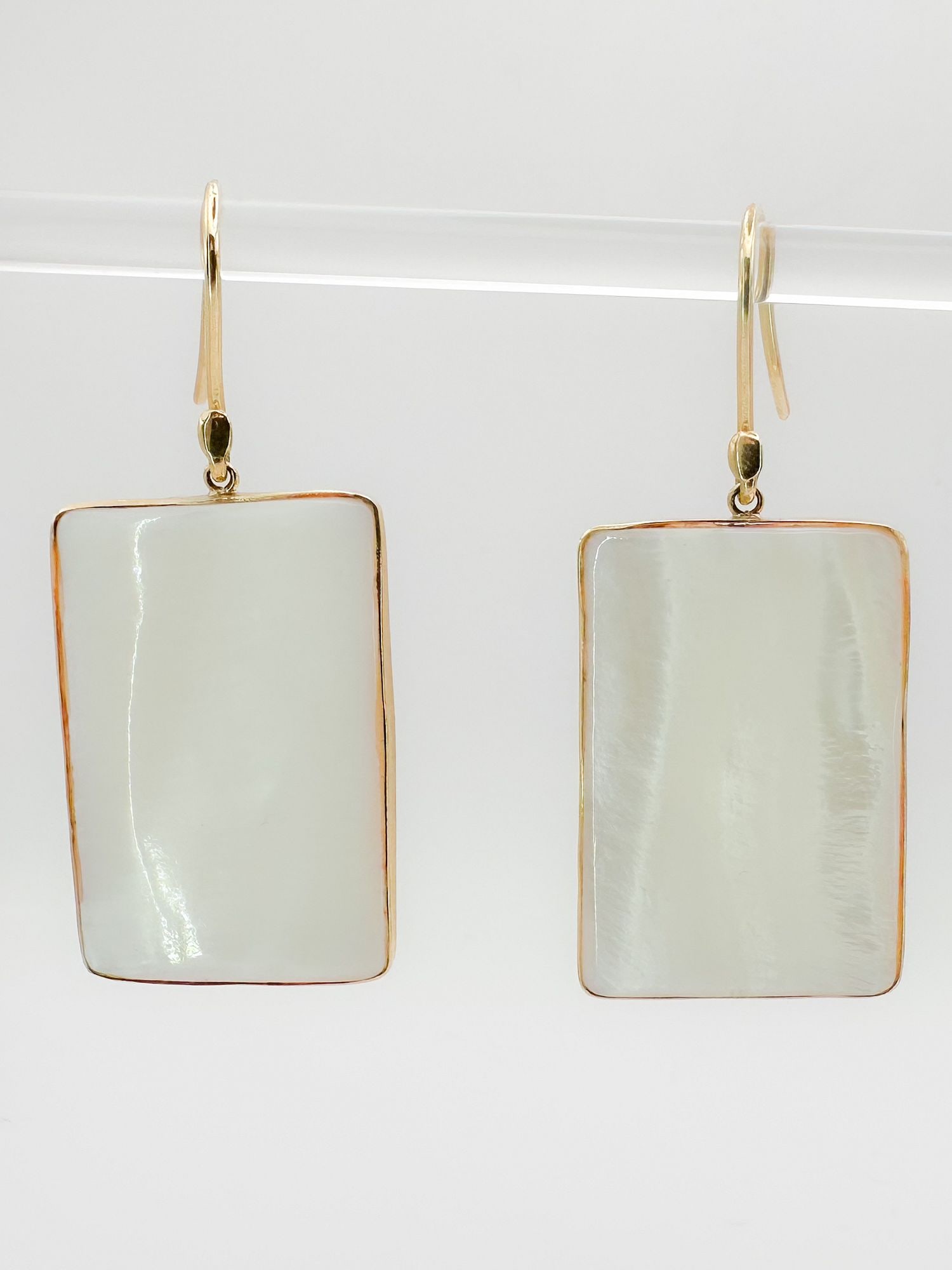 18K Gold Mother of Pearl Rectangle Dangle Earrings: Pair of 18K yellow gold earrings featuring rectangular mother of pearl. Hook style. Dimensions: 7/8 x 1 1/4 inches. Total weight: 13.5 grams.