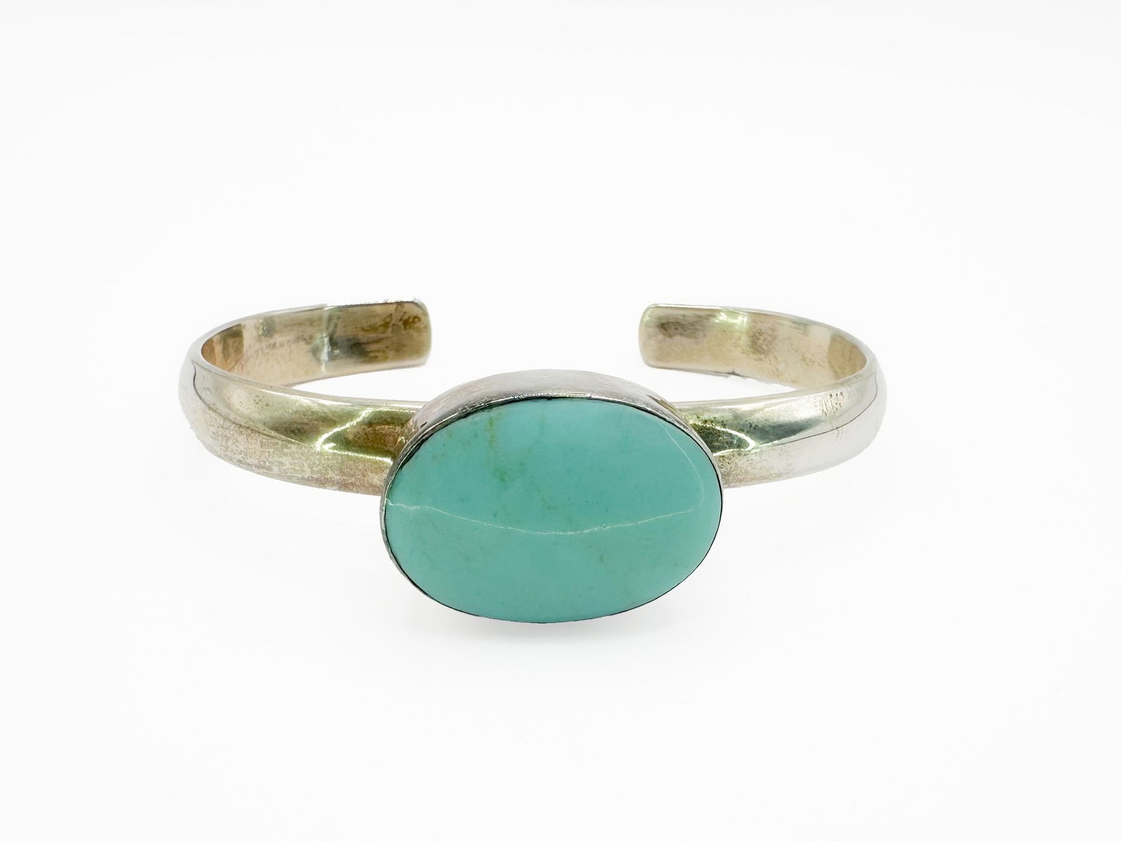 Turquoise & Sterling Silver Cuff Bracelet, Mexico: Sterling silver cuff bracelet featuring a large, oval turquoise cabochon. Marked 'Mexico' and '925'. Cuff measures approximately 5.5 inches with a 1 inch opening. Weighs 35.1 grams.