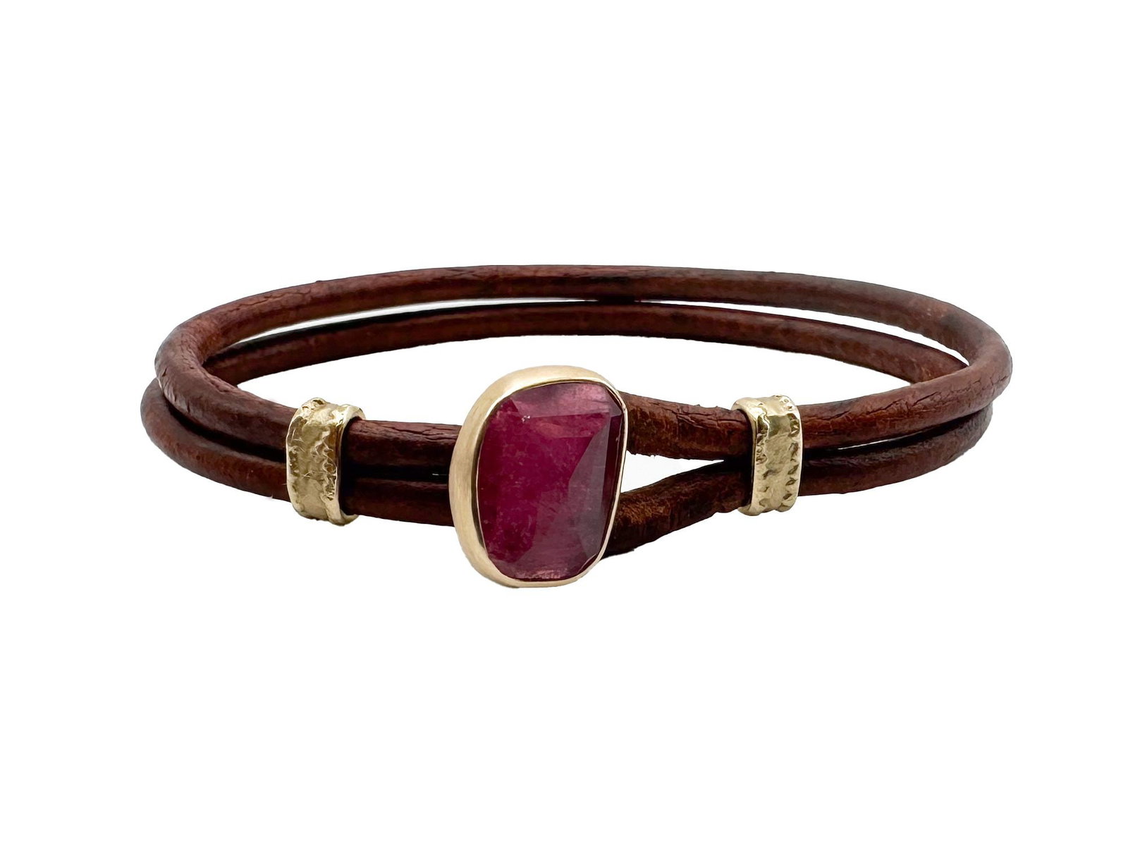 Jamie Joseph 14K Pink Tourmaline Leather Bracelet: A Jamie Joseph 14K bracelet featuring a central pink tourmaline gemstone set in gold. The bracelet is crafted from two strands of dark brown leather and measures 6 1/2 inches in length. The tourmaline