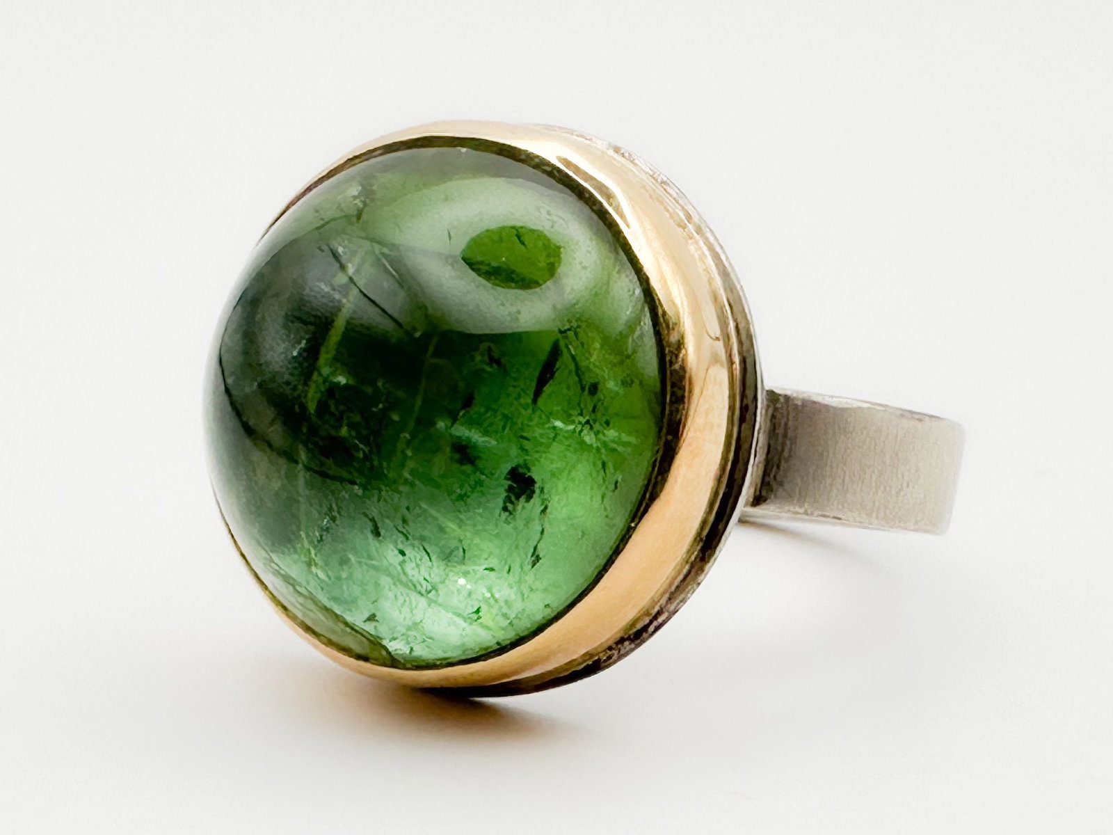 Jamie Joseph Peridot Ring, 14K Gold Bezel & Sterling Silver Band: Jamie Joseph ring featuring a smooth, round peridot cabochon set in 14K gold bezel on a sterling silver band. Size 9.5, 5/8 inch diameter, 11.3 grams.
