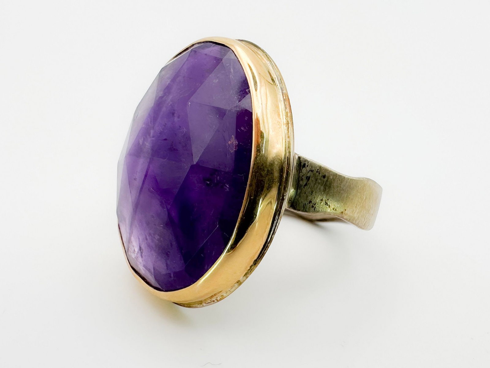 Jamie Joseph Amethyst Ring, 14K Gold Bezel & Sterling Silver Band: Jamie Joseph ring featuring a faceted amethyst stone set in 14K gold bezel with a sterling silver band. Size 9. The face of the ring measures approximately 1 x 3/4 inches. Total weight: 12.9 grams.