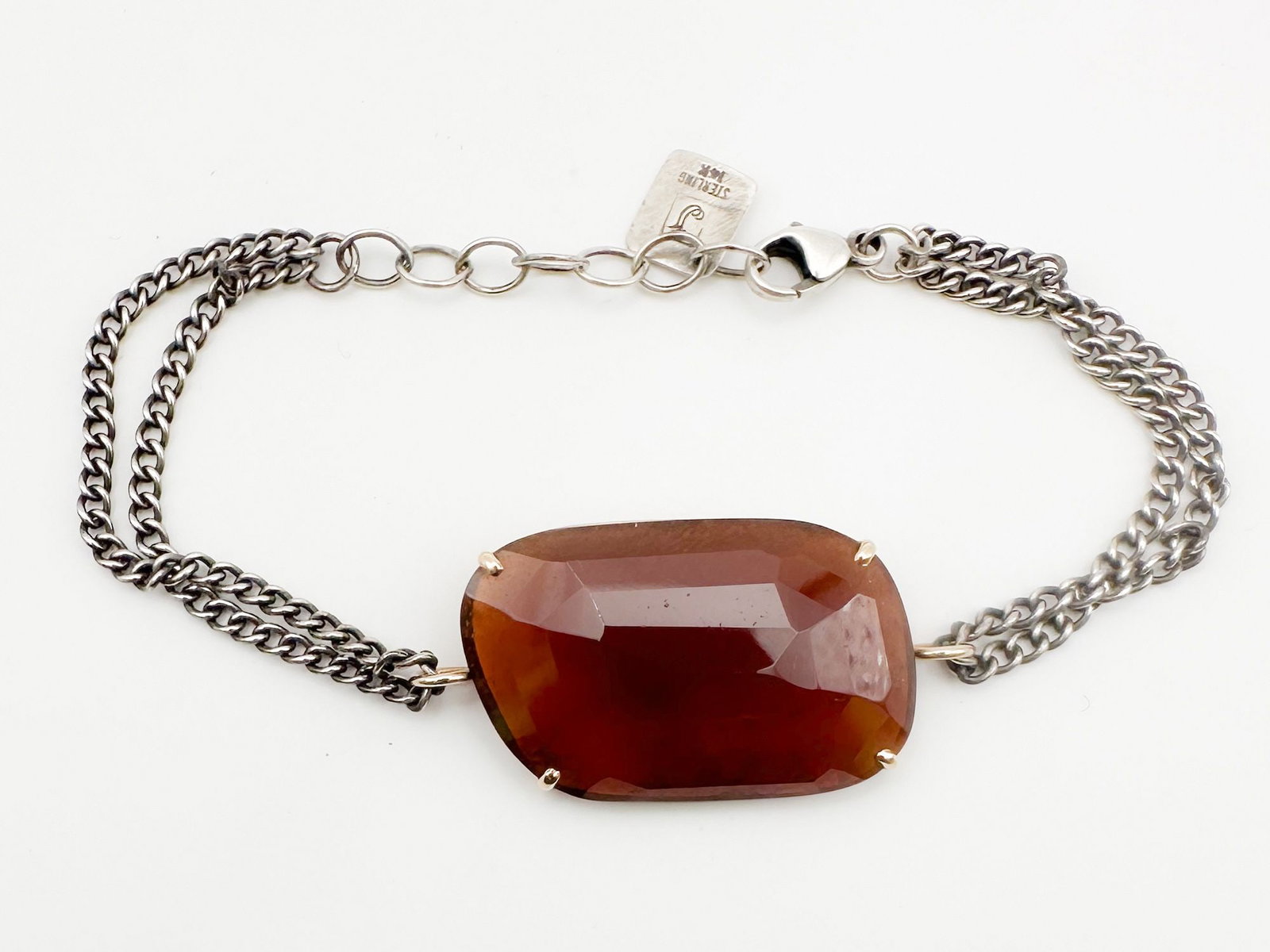 Jamie Joseph Garnet, 14K Gold & Sterling Silver Bracelet: Jamie Joseph bracelet featuring a hessonite garnet in a 14K gold bezel setting, mounted on a sterling silver double link chain. Measures 6 1/2 inches long. Weighs 8.6 grams. Stone measures 1 x 5/8 inc