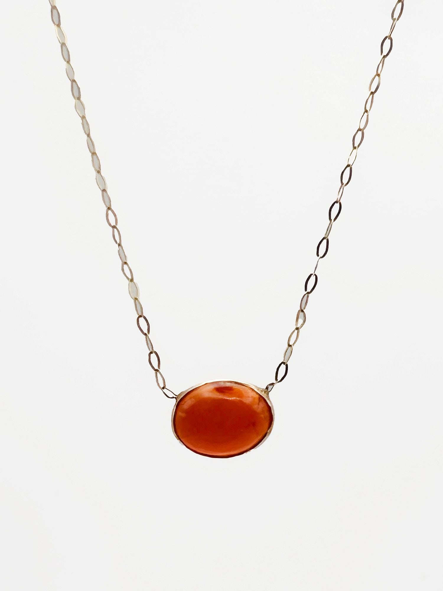 14K Gold Carnelian Cabochon Pendant Necklace, Italy: 14K yellow gold necklace featuring an oval cabochon carnelian pendant. Marked '14KT Italy' on clasp. Necklace is 16 inches long, pendant stone is 3/8 inches wide. Weighs 1 gram.