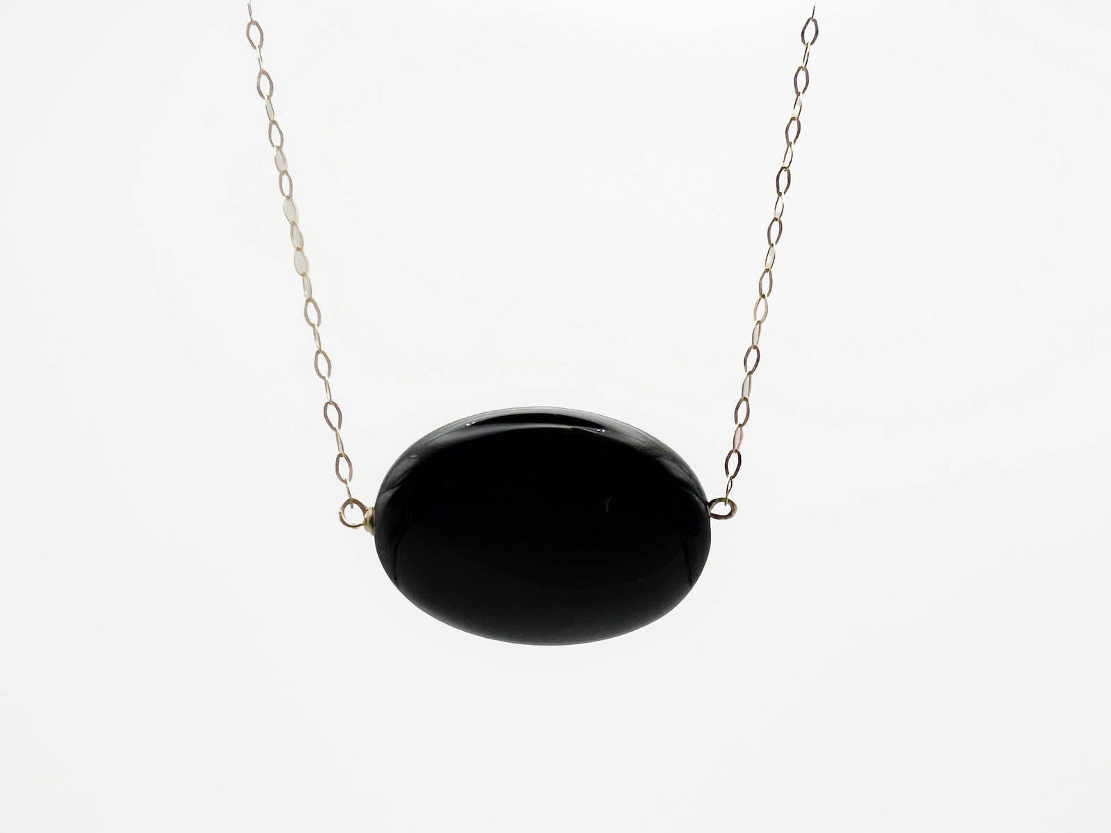 14K Gold & Onyx Pendant Necklace, Italy: 14K yellow gold necklace featuring an oval onyx pendant. Marked Italy. Necklace is 16 inches long, pendant is 7/8 inches wide. Weighs 3.5 grams.