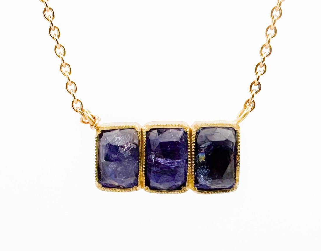 Brooke Gregson 18K Gold Tanzanite Pendant Necklace: Brooke Gregson necklace featuring three bezel-set tanzanite stones in an 18K gold setting. The chain measures approximately 16.25 inches long, and the pendant is 0.625 inches wide. Total weight: 5.4 g