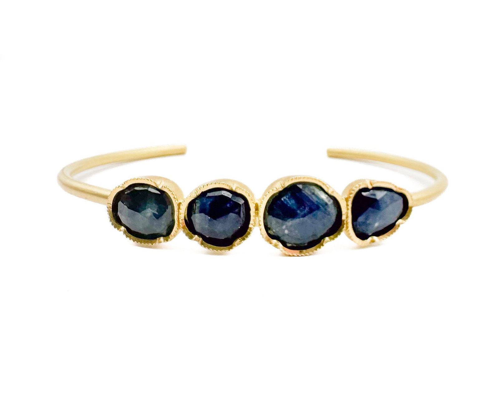 Brooke Gregson 18K Yellow Gold Four Sapphire Cuff Bracelet: Brooke Gregson 18K yellow gold cuff bracelet featuring four bezel-set sapphires. Marked 18K. Interior band measures approximately 5 inches with 7 inches circumference. Designer signed. Weighs 11.9 gra