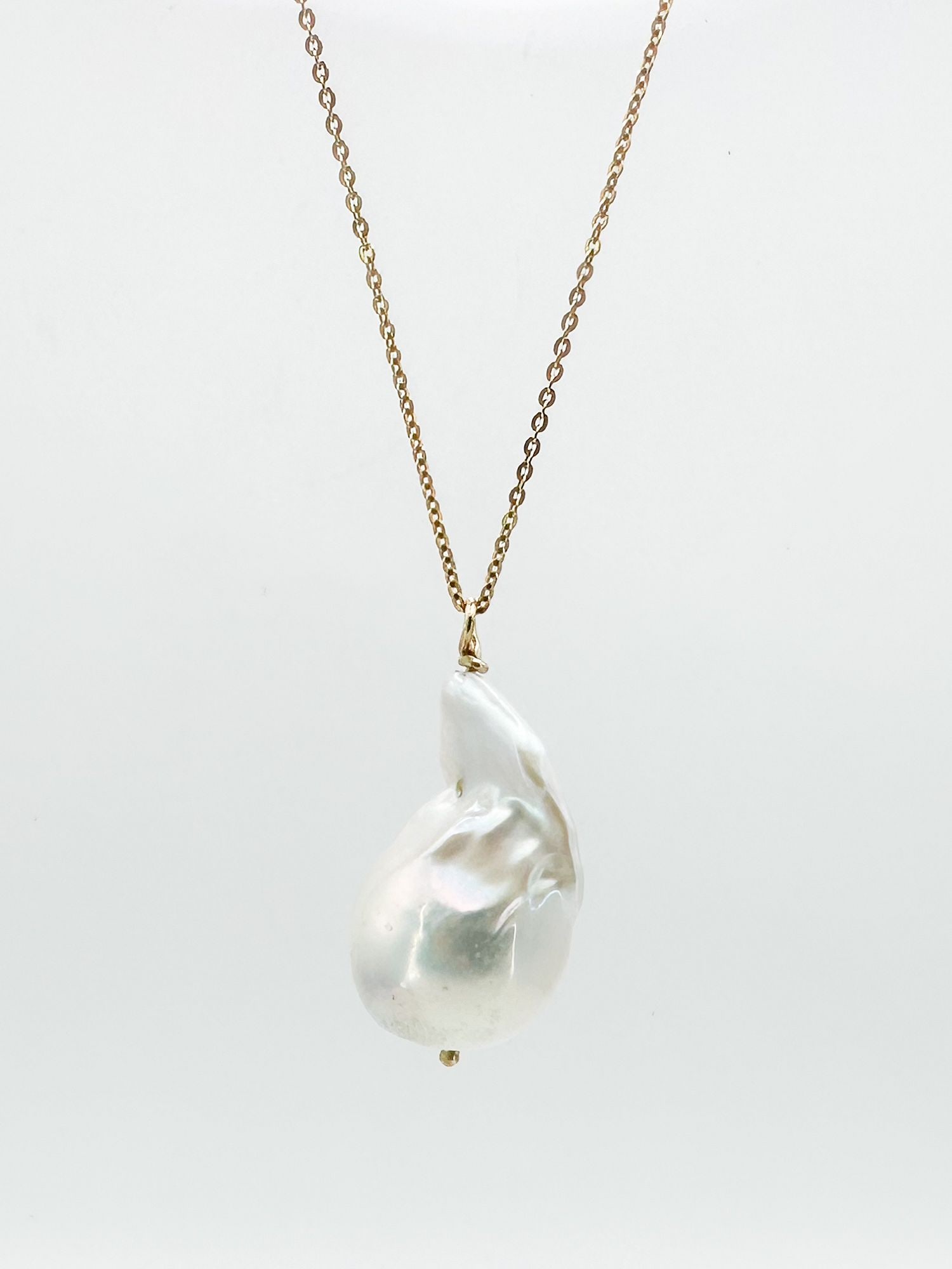 14K Gold & Baroque Pearl Pendant Necklace: 14K yellow gold necklace featuring a large baroque pearl pendant. Necklace is 16 inches long, pearl is 1 inch. Weighs 6.4 grams.