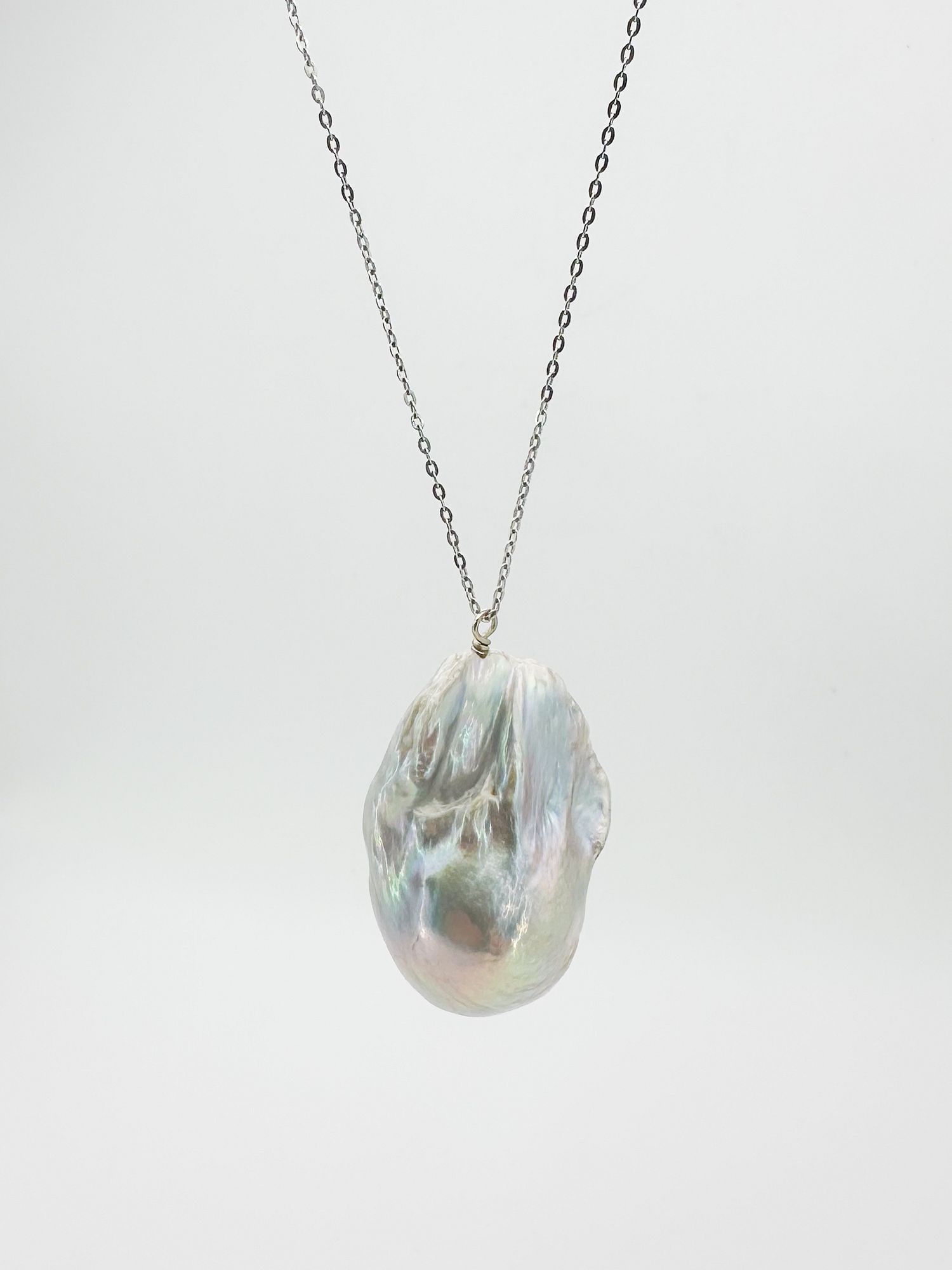 14K White Gold Baroque Pearl Pendant Necklace: 14K white gold necklace featuring a baroque pearl pendant. Chain is 16.5 inches long. Pearl measures 1 1/8 inches. Total weight: 10.4 grams.