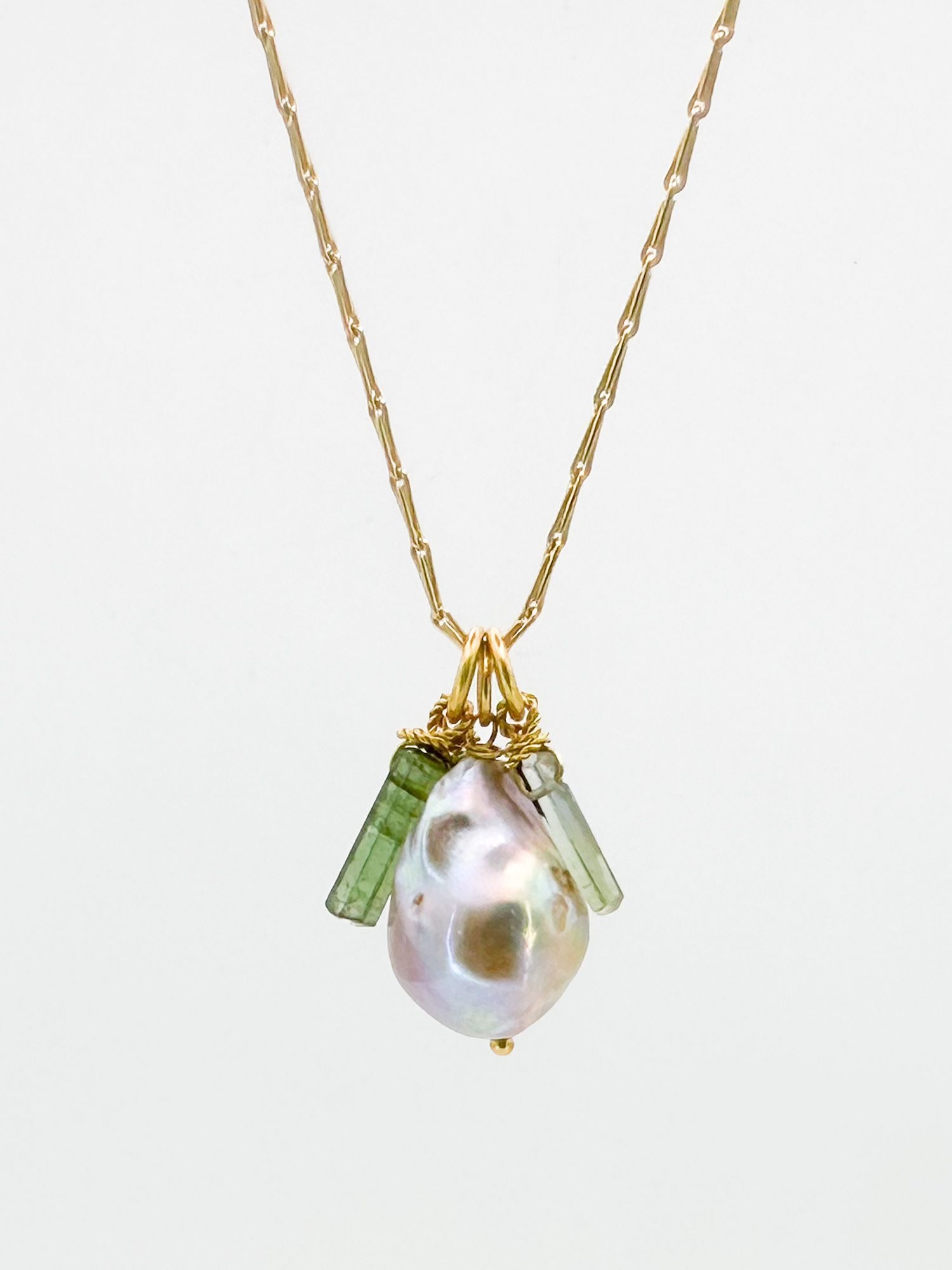 14K Gold Tahitian Pearl & Tourmaline Pendant Necklace: 14K yellow gold necklace featuring a Tahitian pearl pendant accented with green tourmaline. Necklace is 16 inches long, pearl is 5/8 inches long. Weighs 4.9 grams.