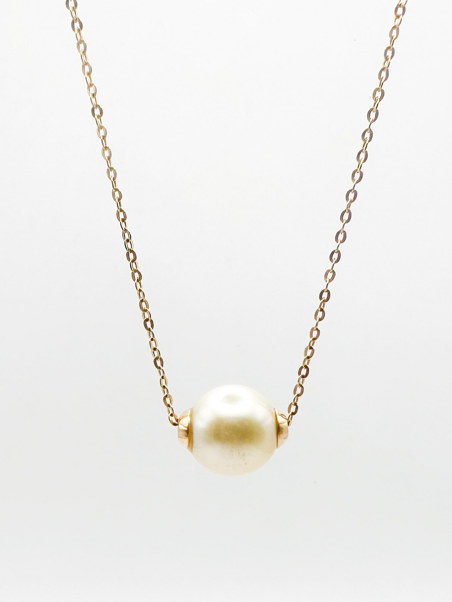 Unoaerre Italy 14K Gold & Pearl Necklace: Unoaerre Italy 14K yellow gold necklace featuring a central pearl. Marked 'Italy' and '14K' on clasp. Length 18 inches, pendant width 1/2 inch. Weighs 3.5 grams.