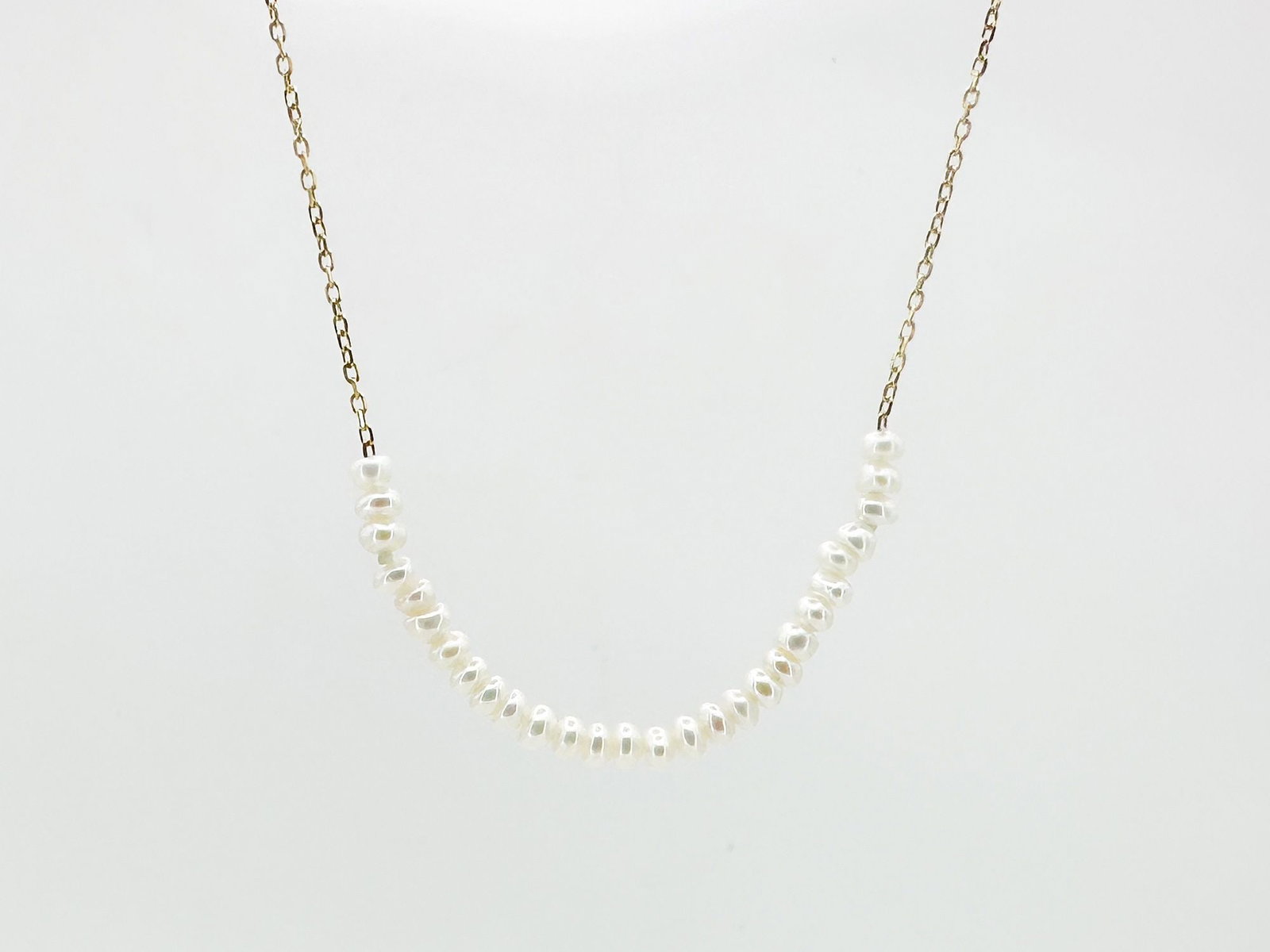 Jennie Kwon 14K Yellow Gold & Pearl Necklace: Jennie Kwon Designs necklace featuring a strand of pearls suspended from a 14K yellow gold chain. Measures 18 inches in length and weighs 1.3 grams.