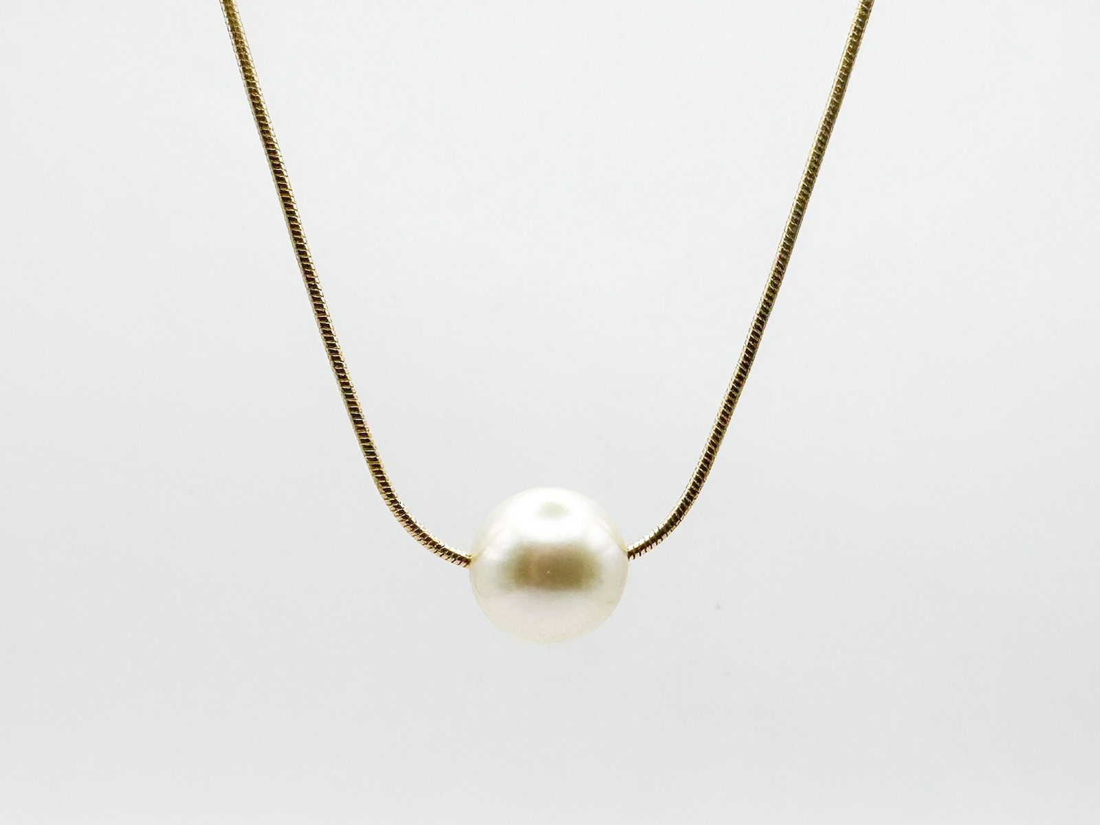 14K Yellow Gold & Pearl Necklace: 14K yellow gold necklace featuring a single pearl. The necklace is 18 inches long, and the pearl measures approximately 3/8 inch in diameter. Total weight: 7.3 grams.