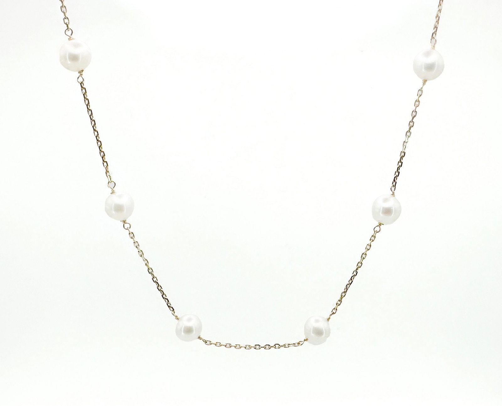 14K Yellow Gold & Pearl Station Necklace: 14K yellow gold necklace featuring round white pearls evenly spaced along the chain. Measures approximately 18 inches in length and weighs 5 grams.