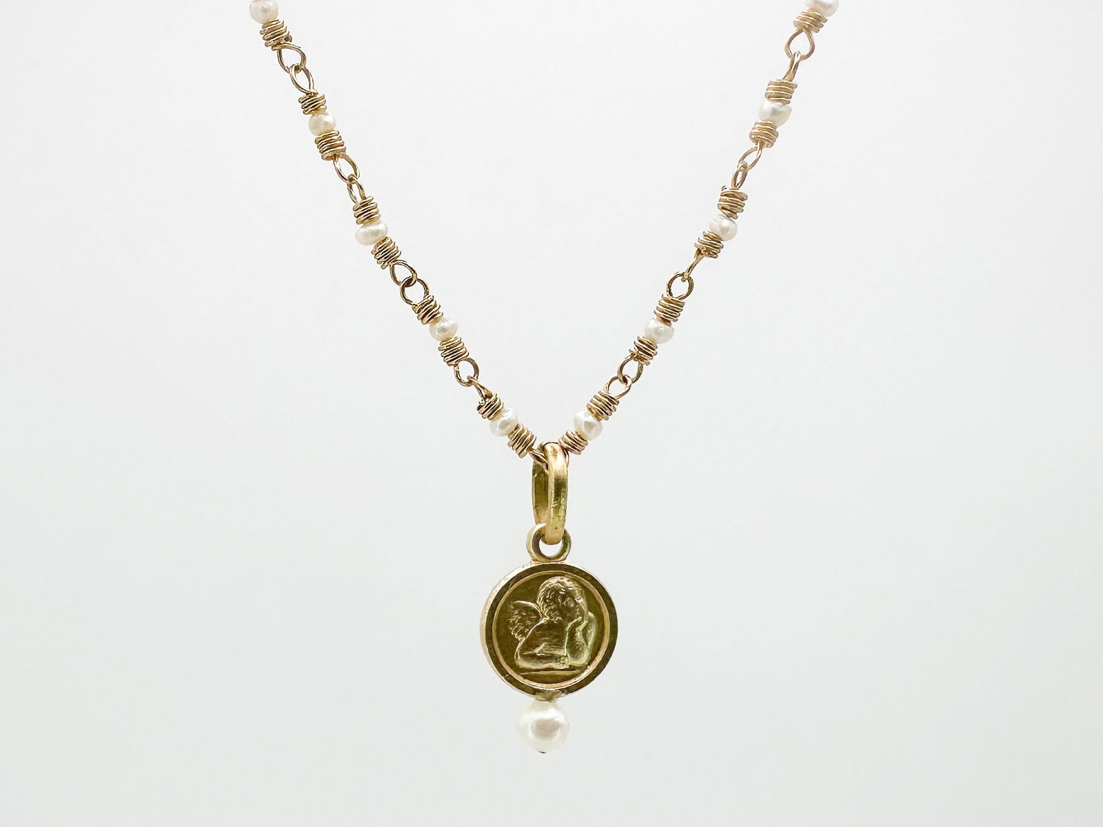 14K Yellow Gold Pearl Necklace w/ Cherub Pendant, Italy: 14K yellow gold necklace featuring pearls and a cherub pendant. Marked 14K Italy. Measures 16 inches long, pendant is 1/2 inch. Weighs 3.8 grams.
