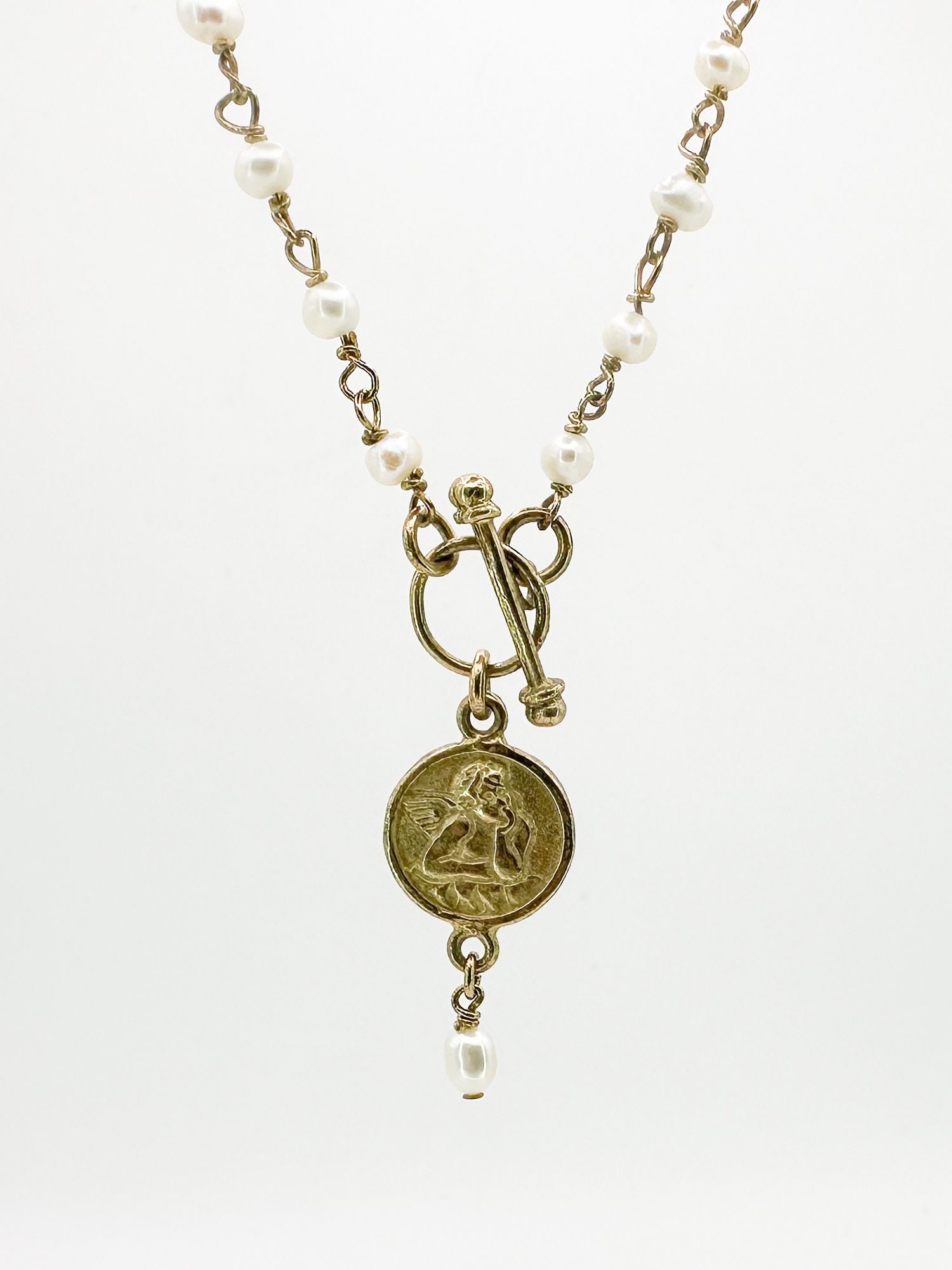 Sterling & Pearl Necklace with Cherub Pendant: Sterling silver necklace featuring pearls and a cherub pendant. The necklace is 16 inches long, and the pendant is 1 inch in diameter. T-bar clasp.