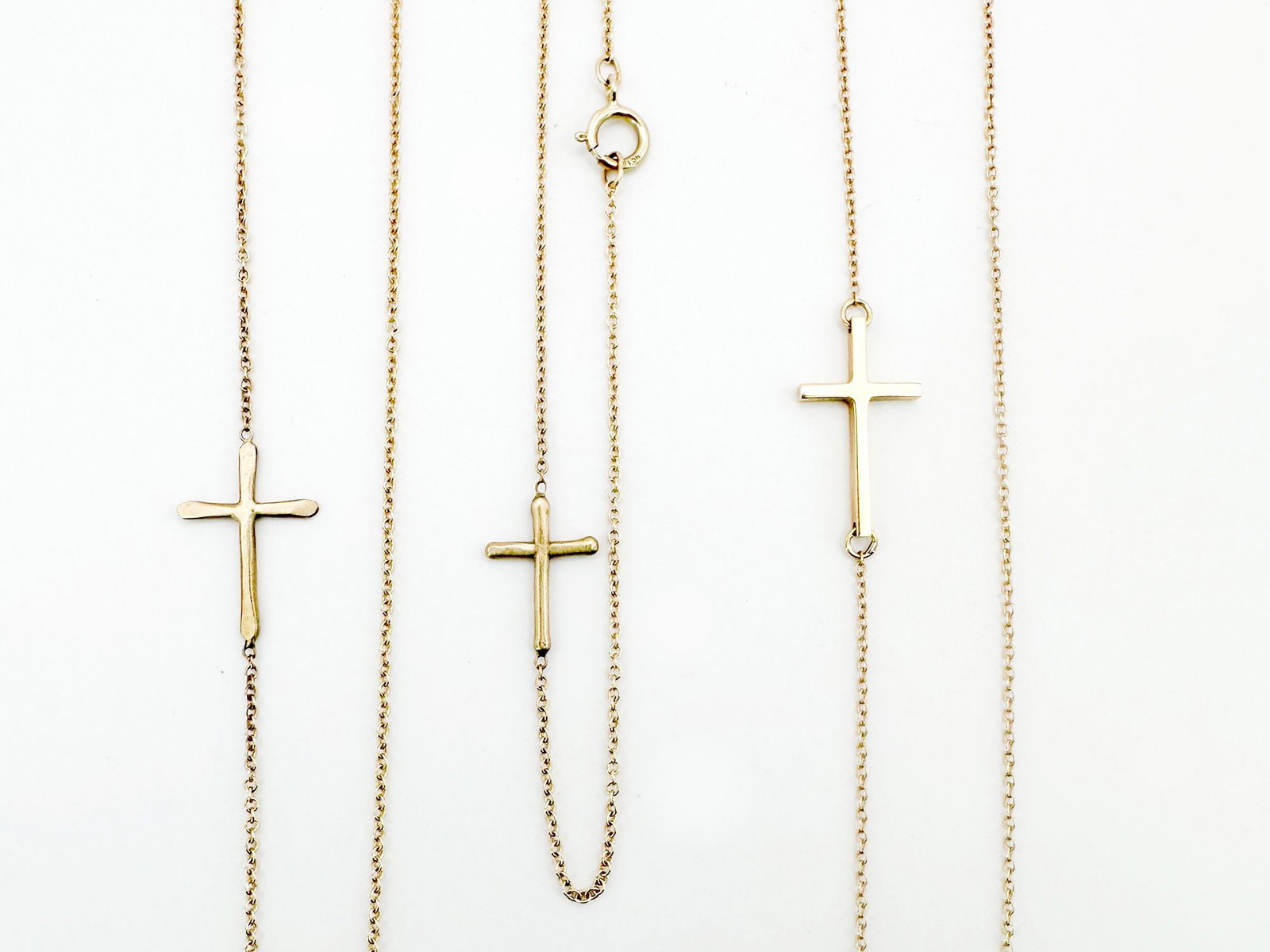 Lot of 3 10k and 14K Crosses on Link Chains, Necklaces and Bracelet: This lot features three delicate gold pieces: a 10k gold necklace and bracelet set (17" and 7" respectively) with matching crosses, and a 14k gold necklace (16") with a cross pendant. T