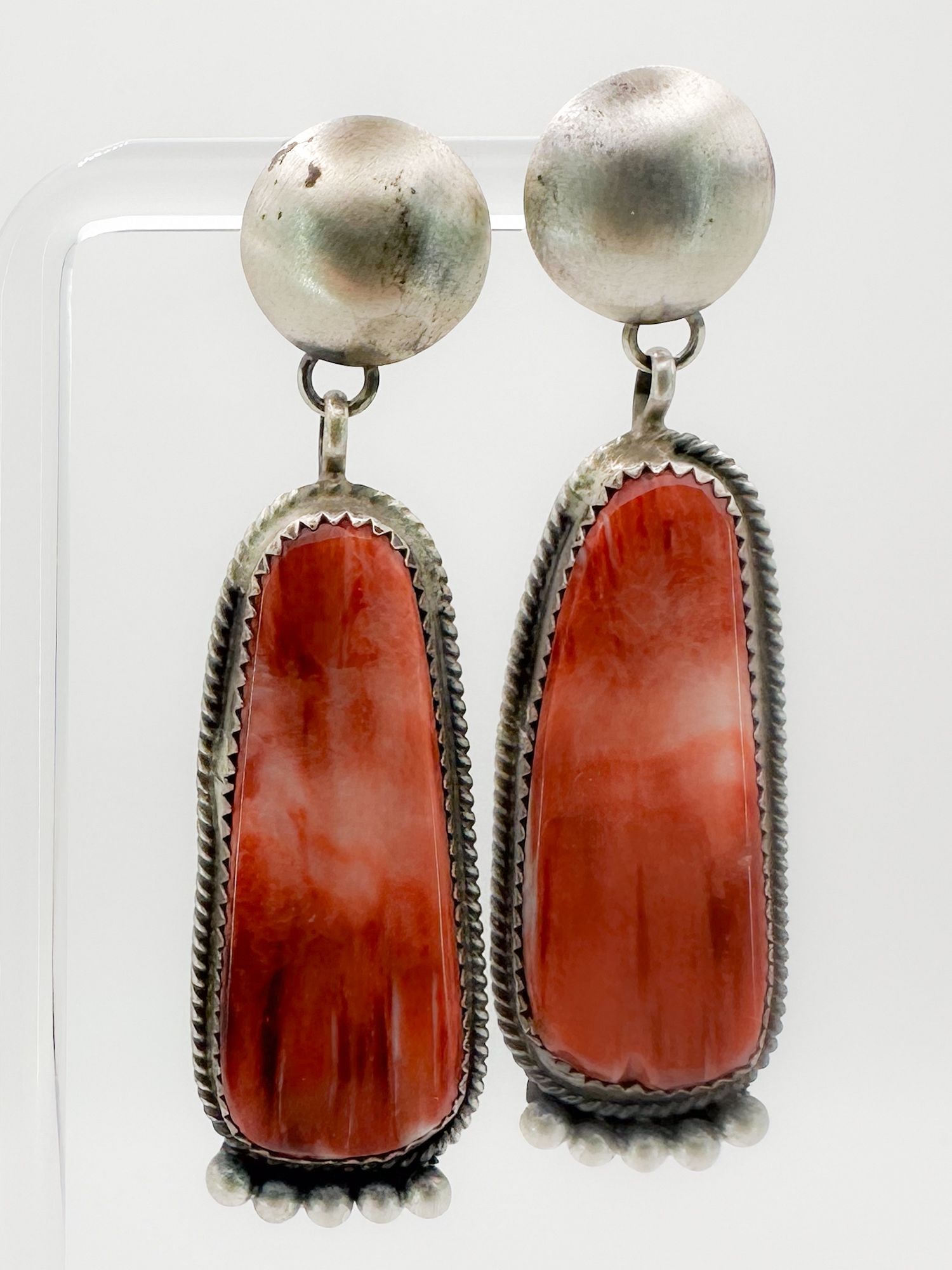 Sterling Silver & Coral Drop Earrings: Pair of sterling silver earrings featuring coral drops. Marked 'Sterling SW'. Each earring measures 2 1/4 inches long and weighs 14.1 grams.