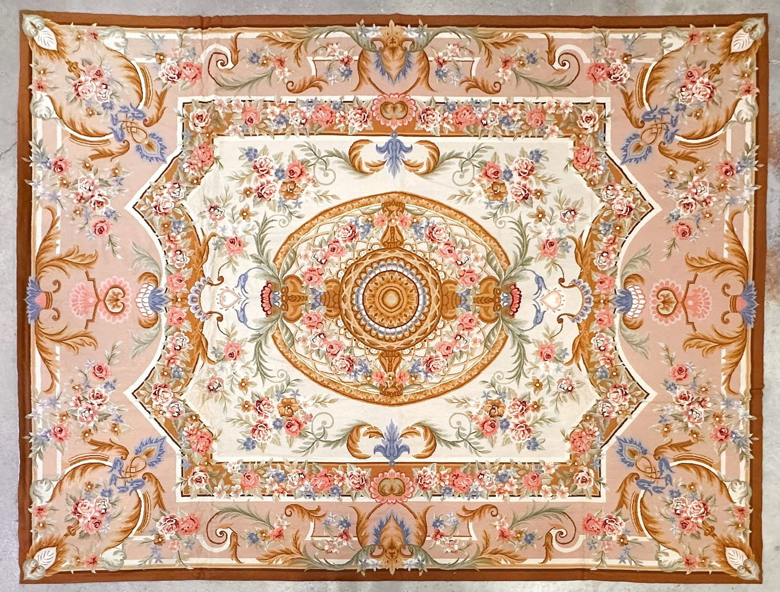 Vintage Aubusson Tapestry: Hand woven. Depicts ornate floral motifs and flourishes in shades of blush and cream with embellishments in shades of green, blue, pink, and brown. Approximately 146 in H x 108.5 W. Weighs approximate