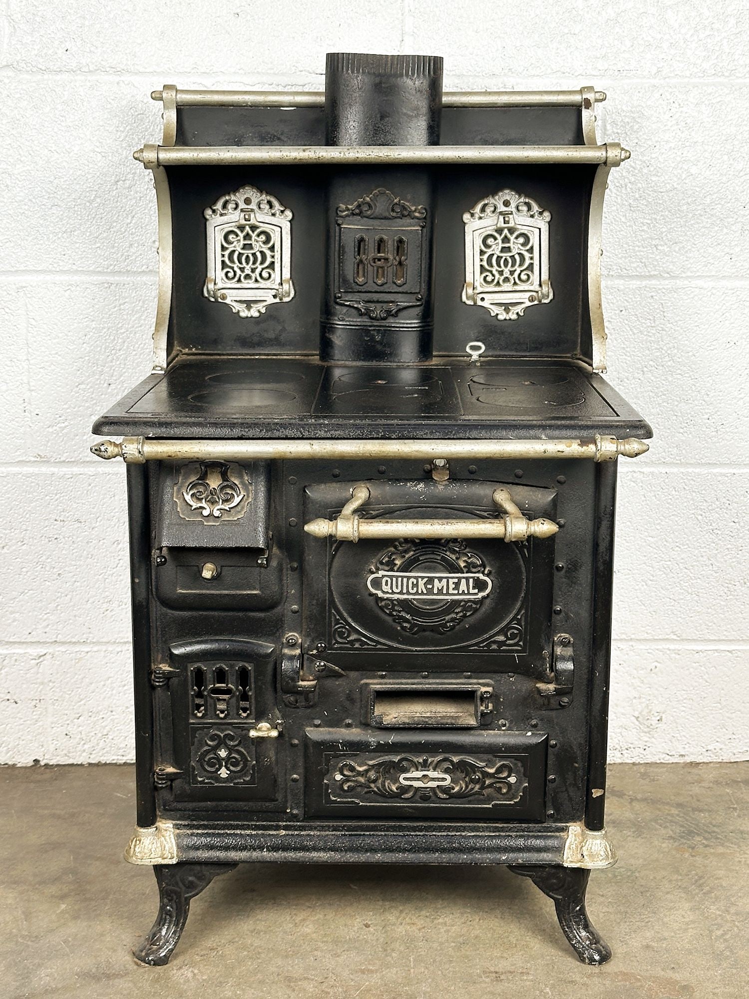 Antique Cast Iron Miniature Salesman Sample Quick Meal Stove: This antique was used to sample the latest technology in cast iron stoves. Black with silver details. Approximately 30 in H x 17 in W x 16 in D. LOCAL PICK UP INFORMATION: Wednesday, June 10, 10:00 AM