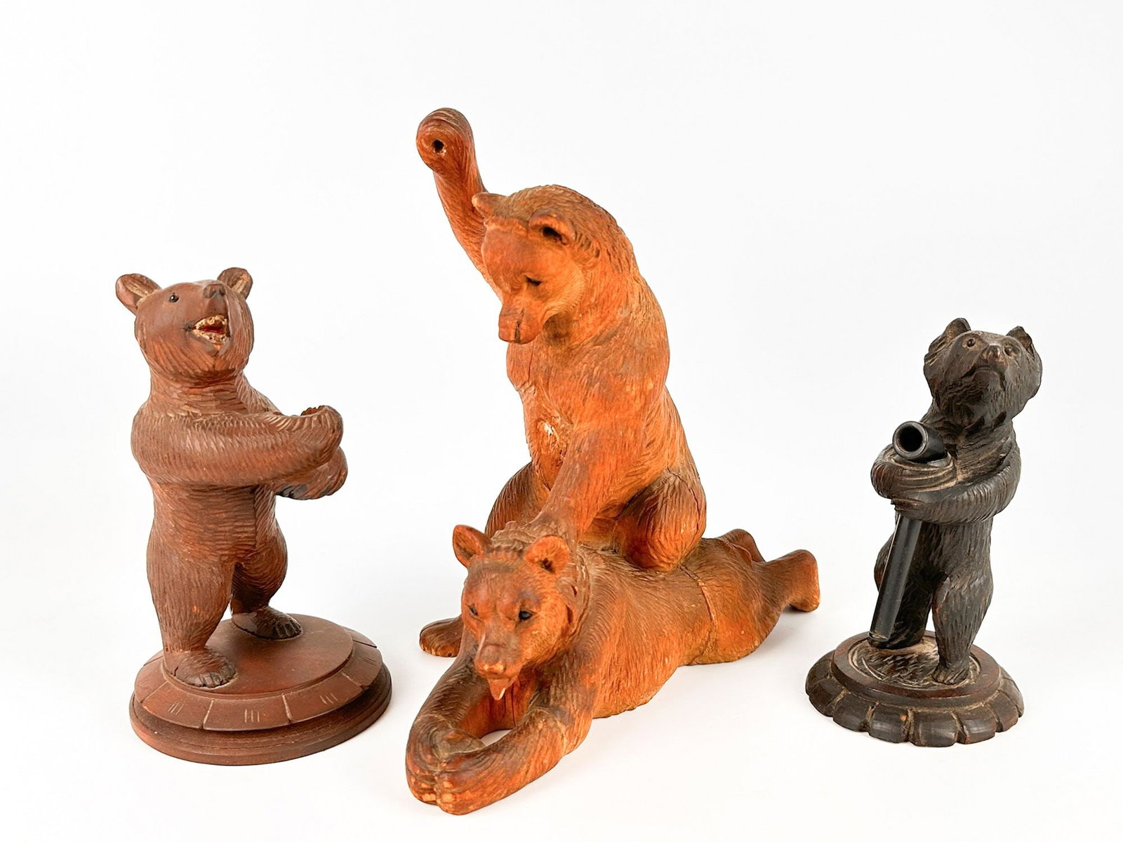 Lot of 3 Antique Black Forest Hand Carved Wood Bears: Lot includes three hand carved figurines with intricate fur details. One bear is holding a pipe. Another has handholds for a pipe. Bears range in size from approximately 5.5 in H x 3 in W x 3 in D to 