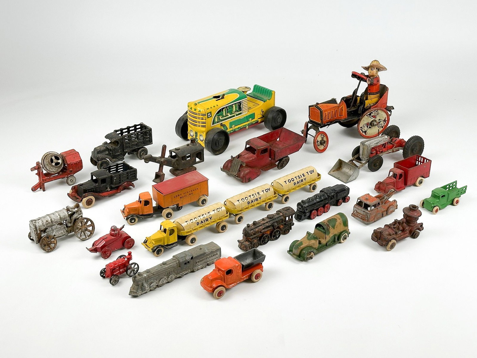 Collection of 24 Vintage Toy Industrial Vehicles: Lot includes toys made of metal, some with rubber tires. Sizes range from approximately 1.25 in H x 1.5 in W x 2 in D to 4 in H x 5 in W x 8 in D. Total weight is approximately 7 lbs 6 oz. LOCAL PICK 