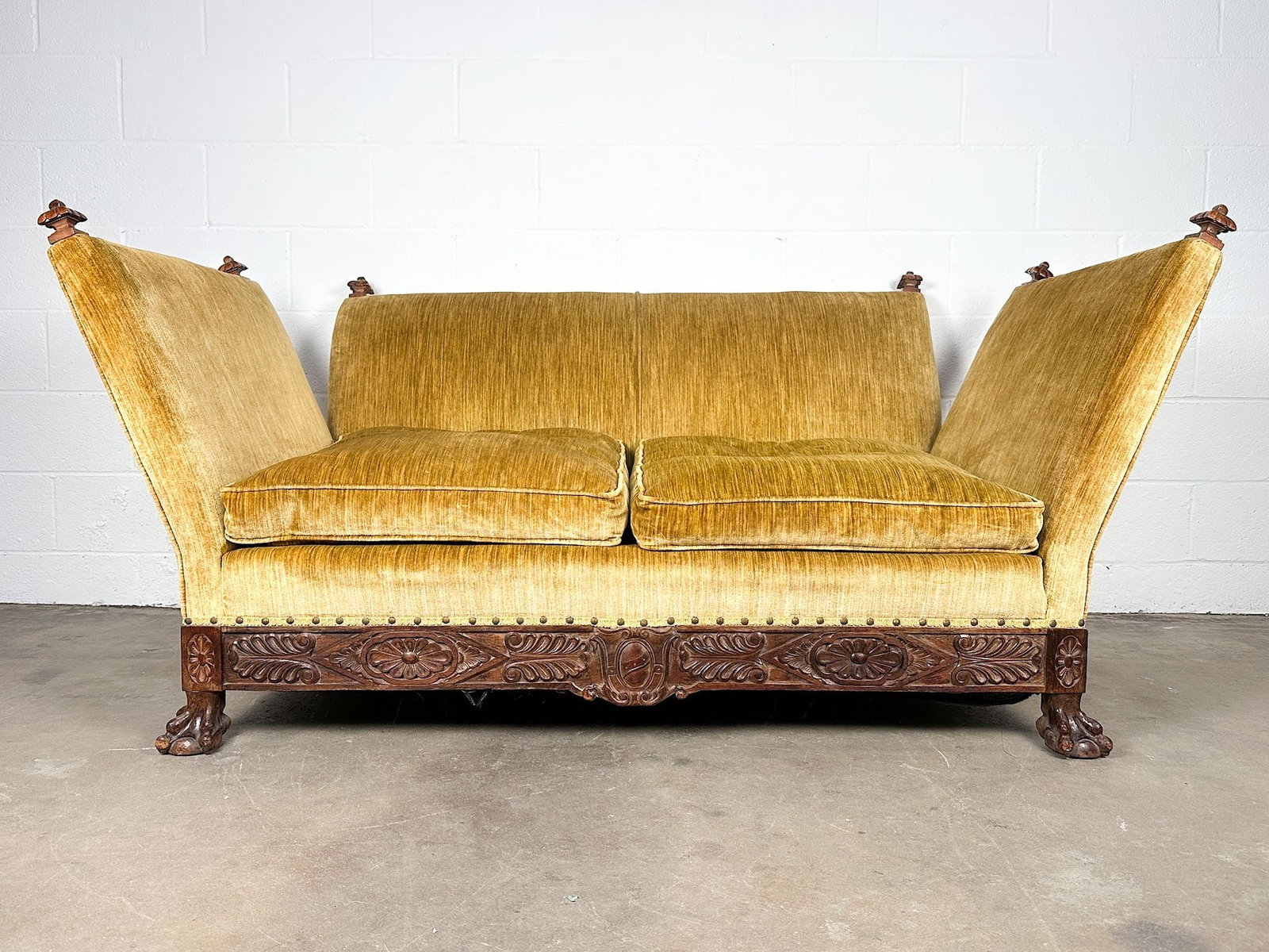 Antique Goldenrod Velvet Knole Drop Arm Sofa with Carved Wood Base and Claw Feet: Goldenrod velvet upholstery. Detailed carvings throughout. Finials on corners. Claw feet. Dimensions: Couch is approx. 33 in H x 69.5 in W x 38 in D. LOCAL PICK UP INFORMATION: Wednesday, July 8, 10:0