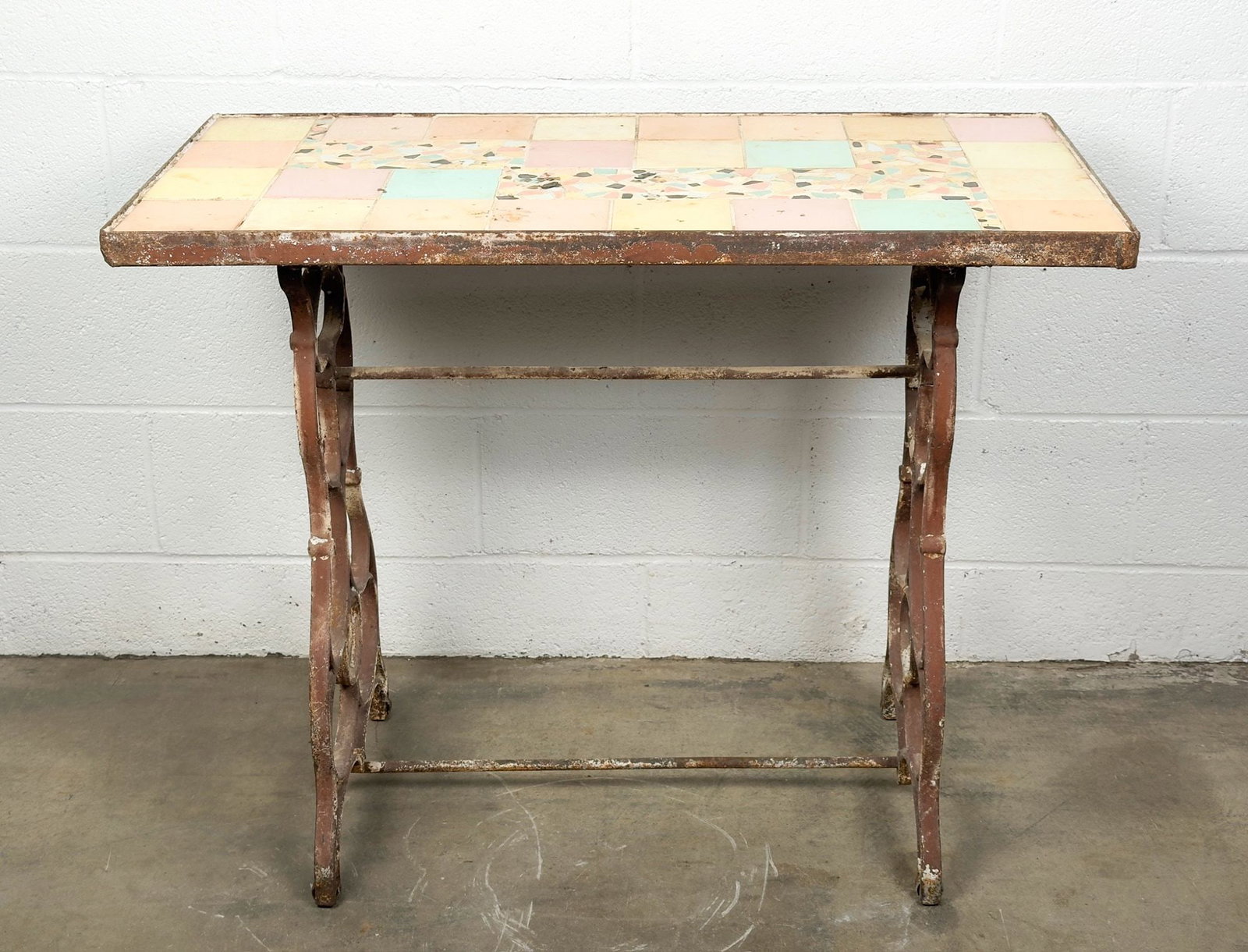 Antique Wrought Iron Garden Bistro Table with Folk Art Tile Mosaic Top: Wrought iron base and frame with tile table top. Tiles are in pastel shades. Approximately 29 in H x 36 in W x 18 in D. LOCAL PICK UP INFORMATION: Wednesday, July 8, 10:00 AM - 2:00 PM 8059 Foothill B